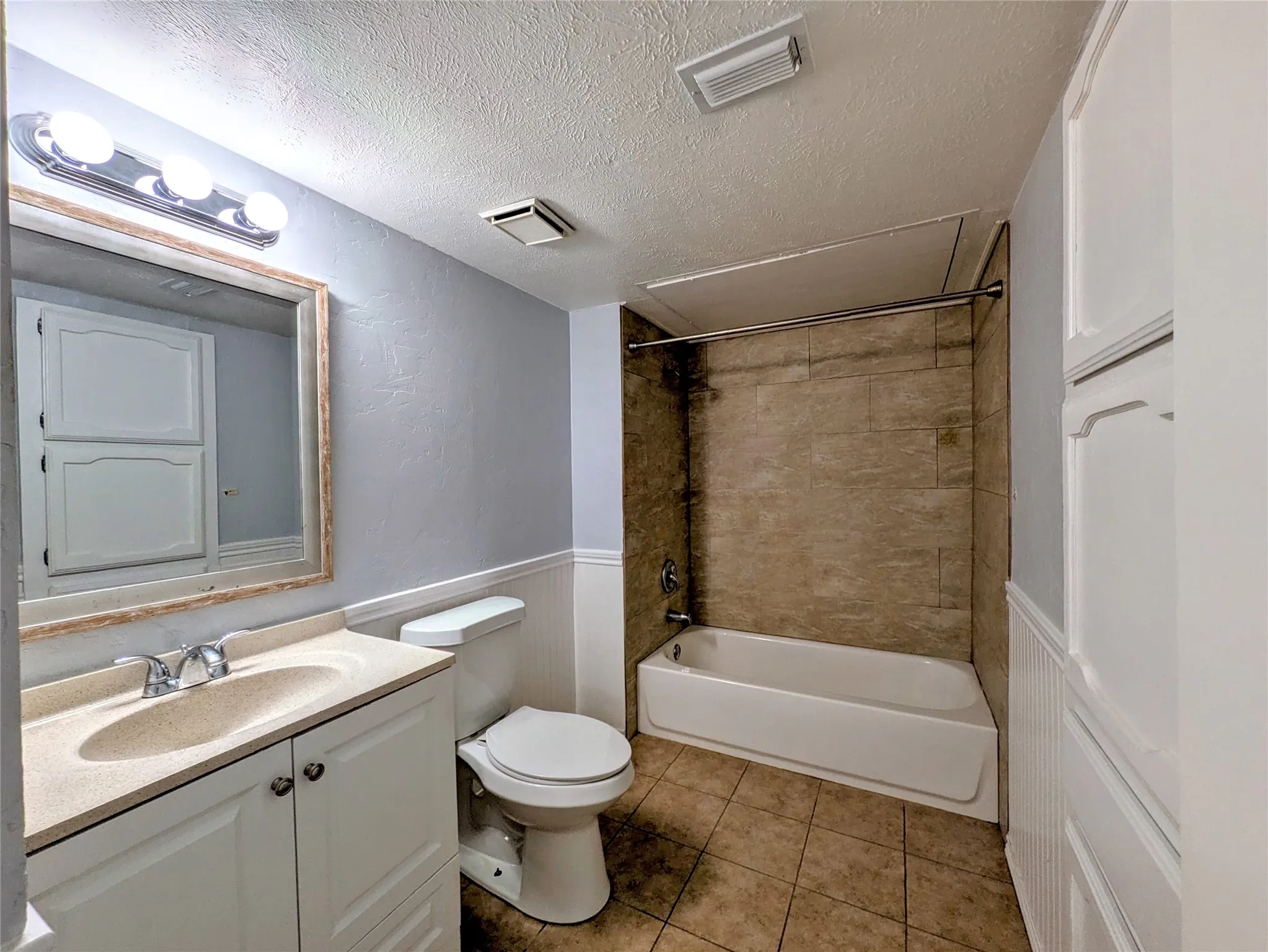 Vanity with integrated sink, chrome faucet, and framed mirror