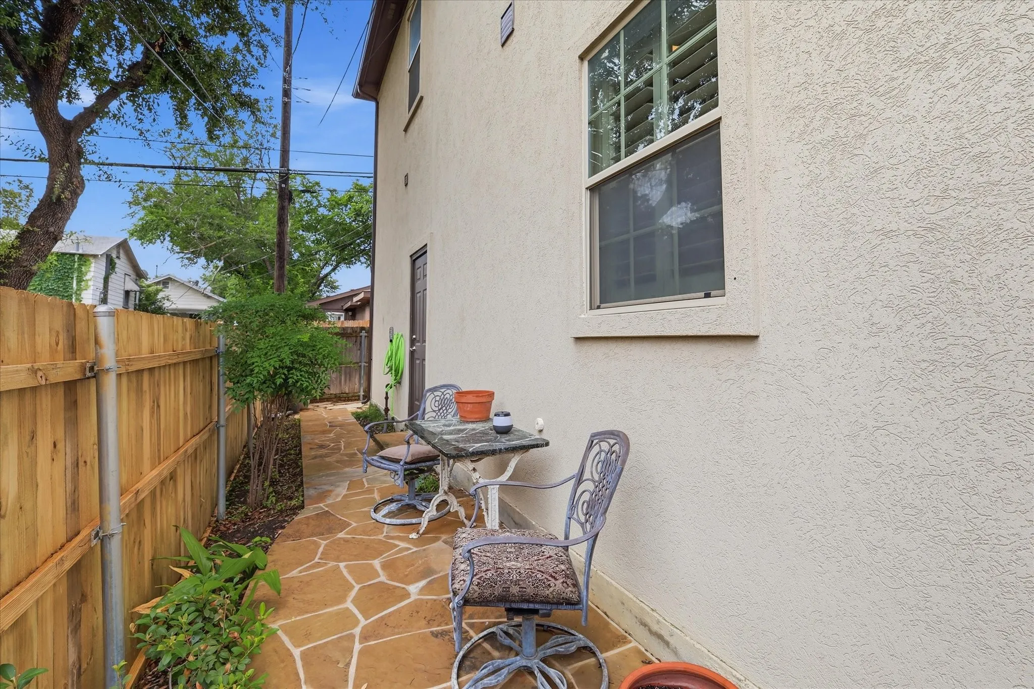 A cozy side patio is landscaped and perfect for evening cookouts