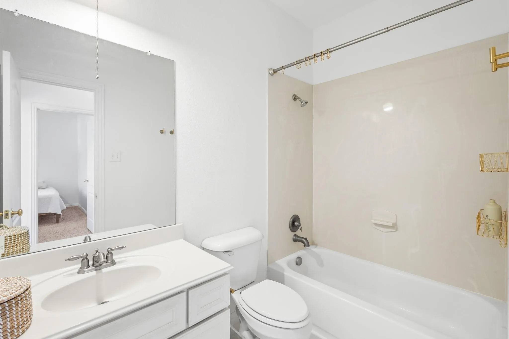 White vanity with integrated sink, chrome faucet, and expansive wall mirror