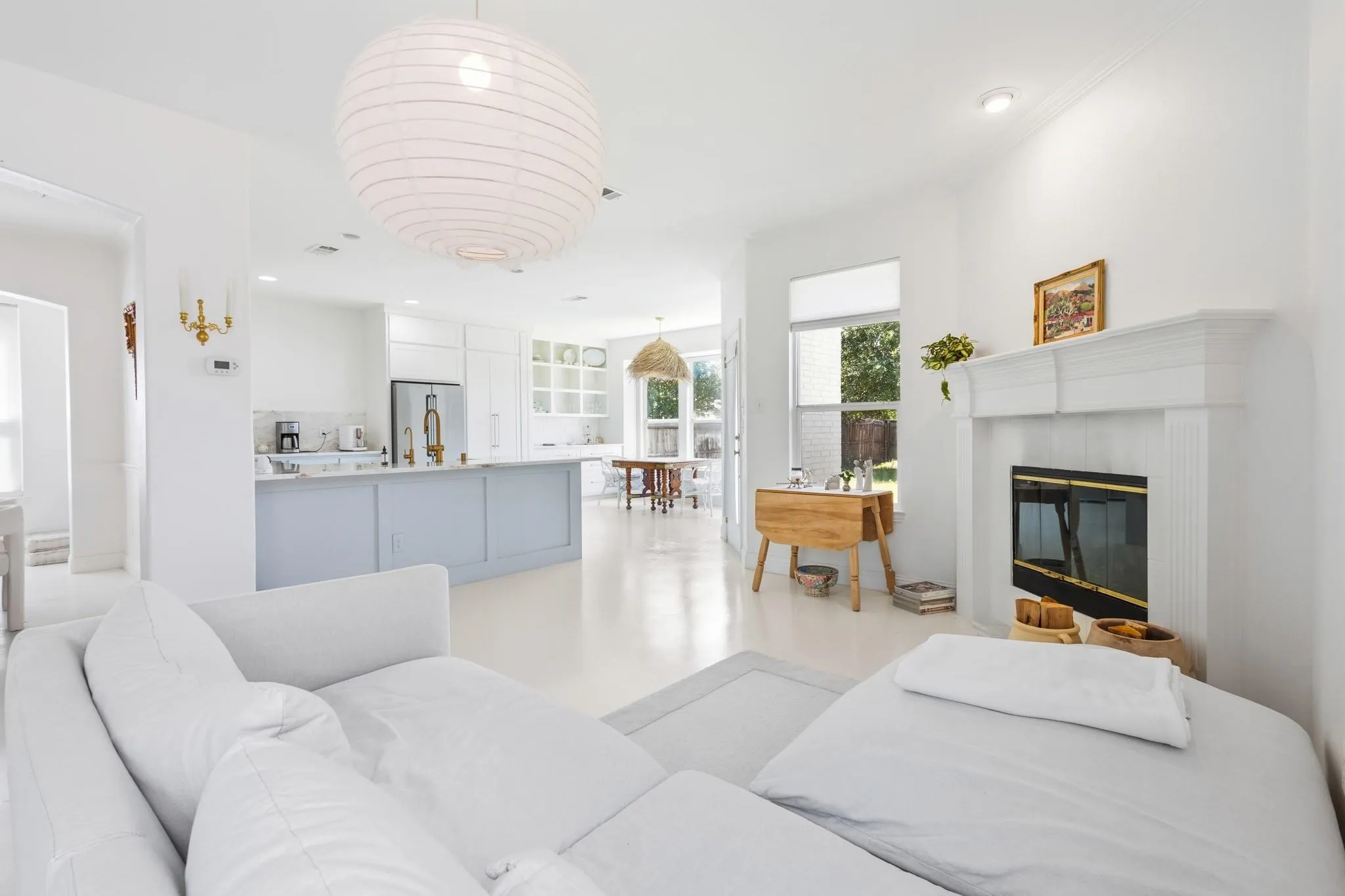 Spacious open-concept interior with a white fireplace, light-toned flooring, and recessed lighting
