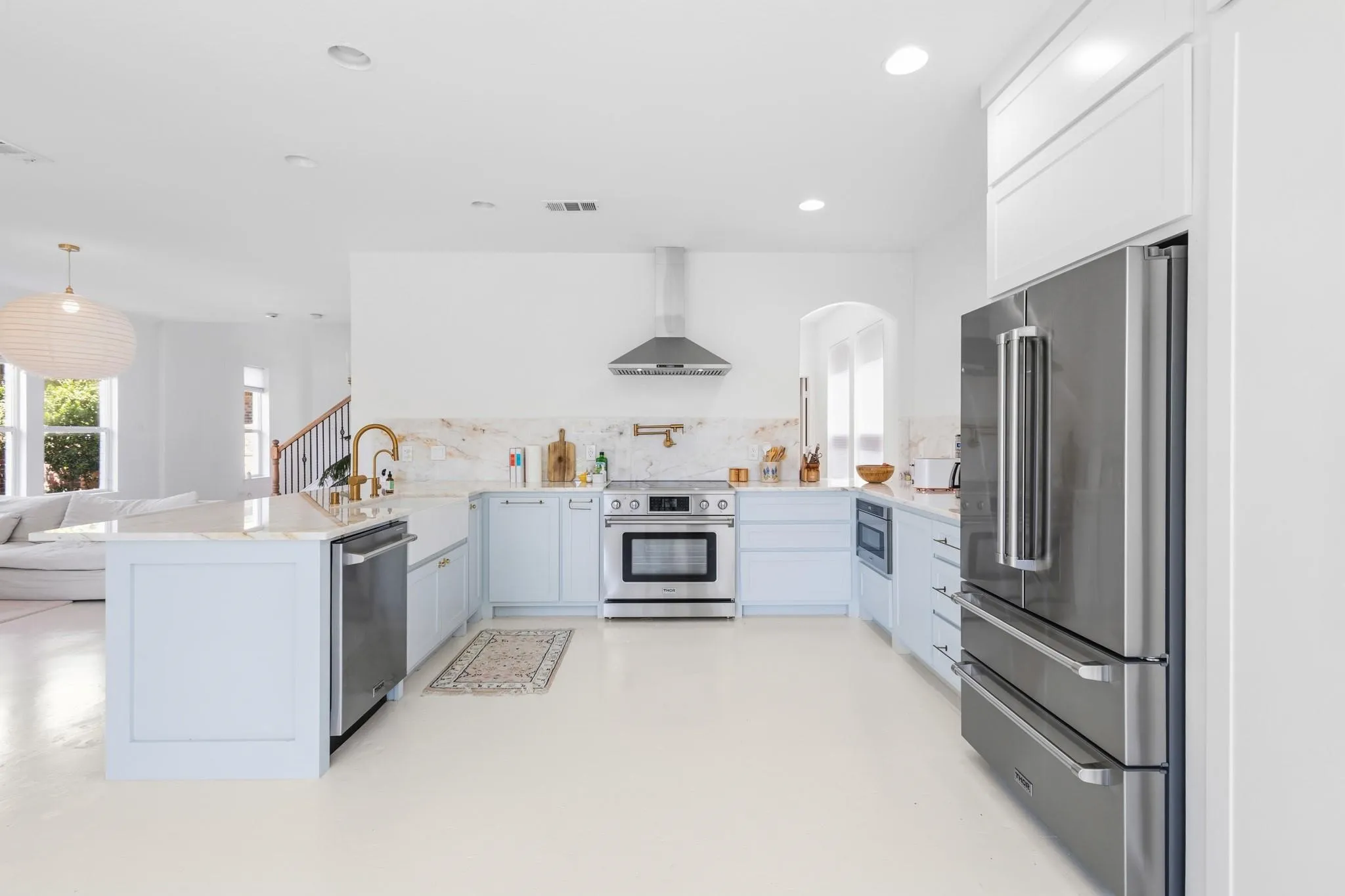 Open-concept kitchen featuring light-toned cabinetry, stainless steel appliances, a kitchen island, and recessed lighting