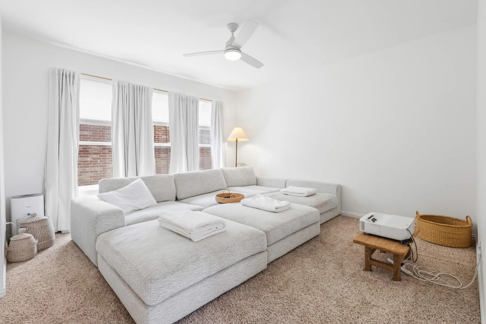 Bright interior with multiple windows, a ceiling fan, and carpeted flooring