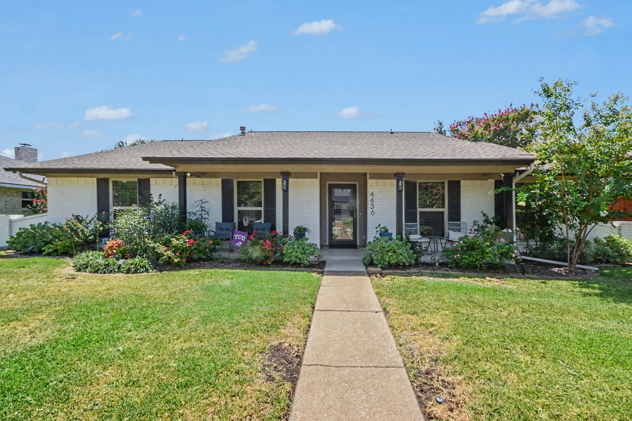 Classic single-story home featuring a welcoming front facade with a covered porch, multiple French doors, and black-trimmed windows