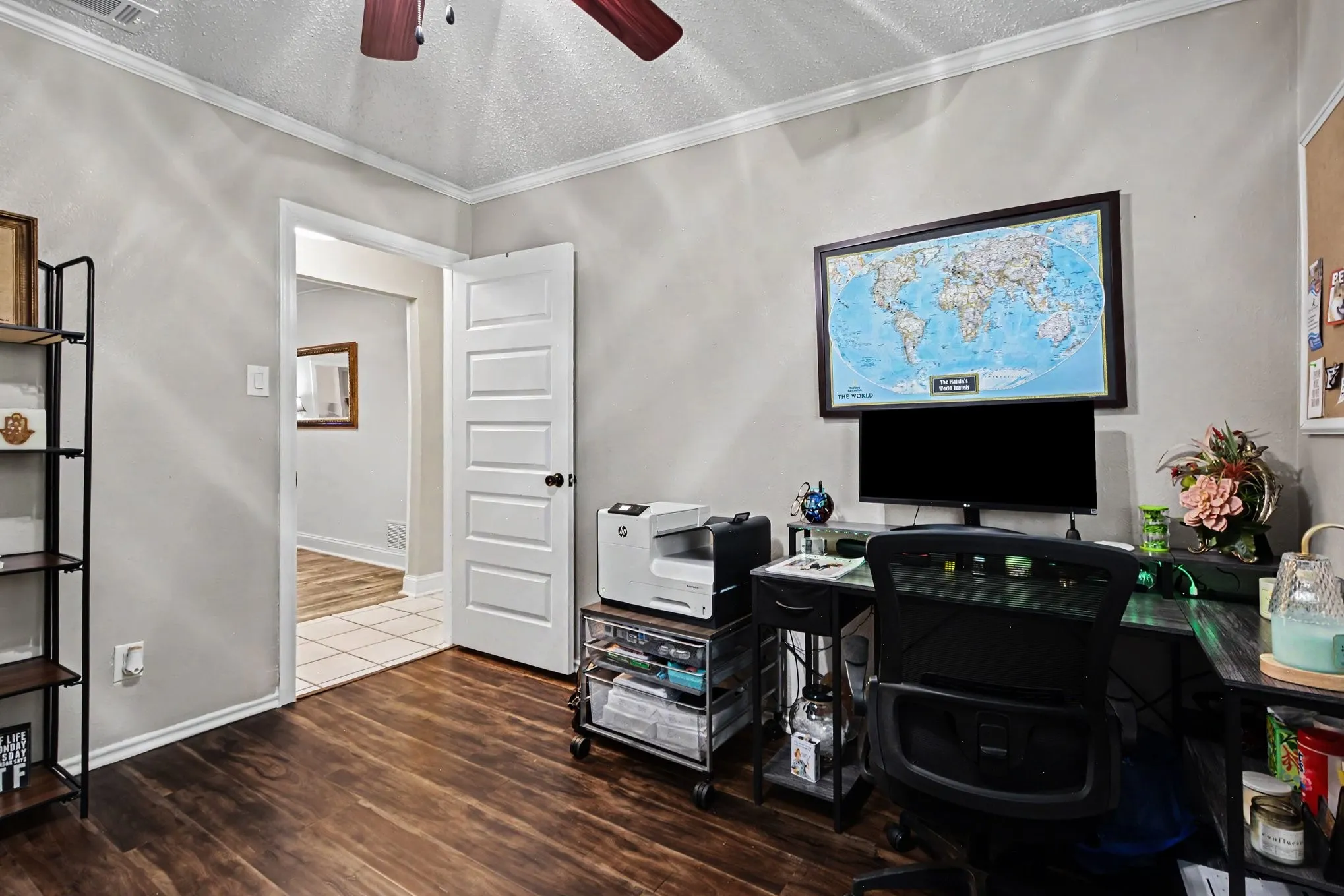 Wood-finish flooring, crown molding, and a five-panel interior door