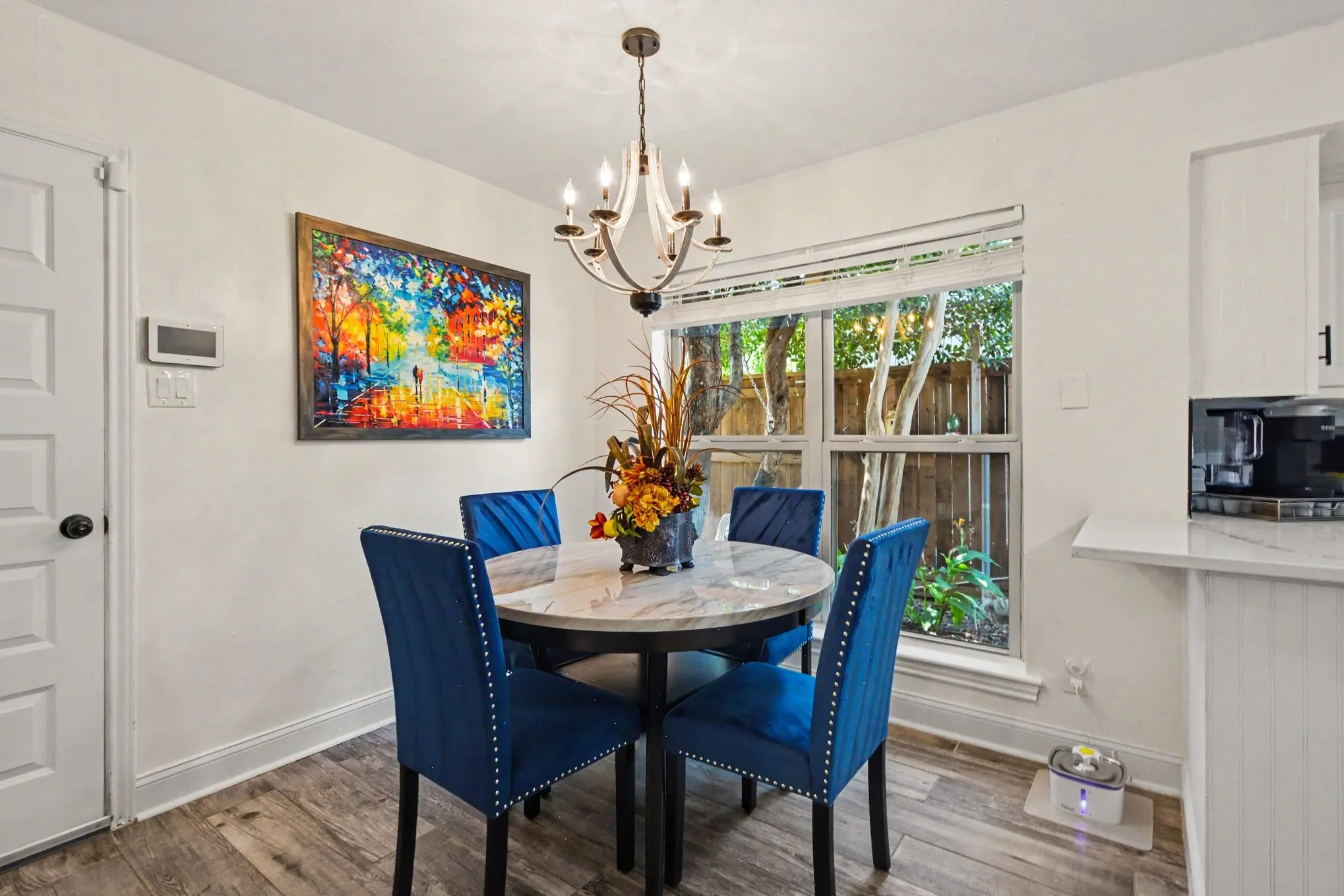 Recessed window with wood-look blinds, wood-finish flooring, and a white six-panel door