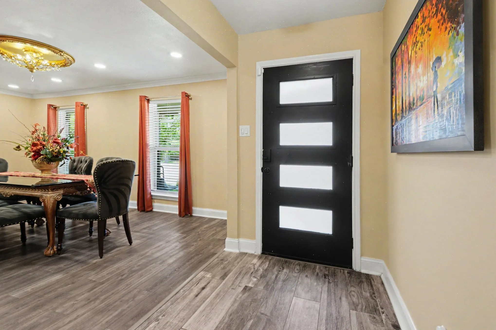 Modern entry door with four frosted glass panels, wood-finish flooring, and recessed ceiling lighting