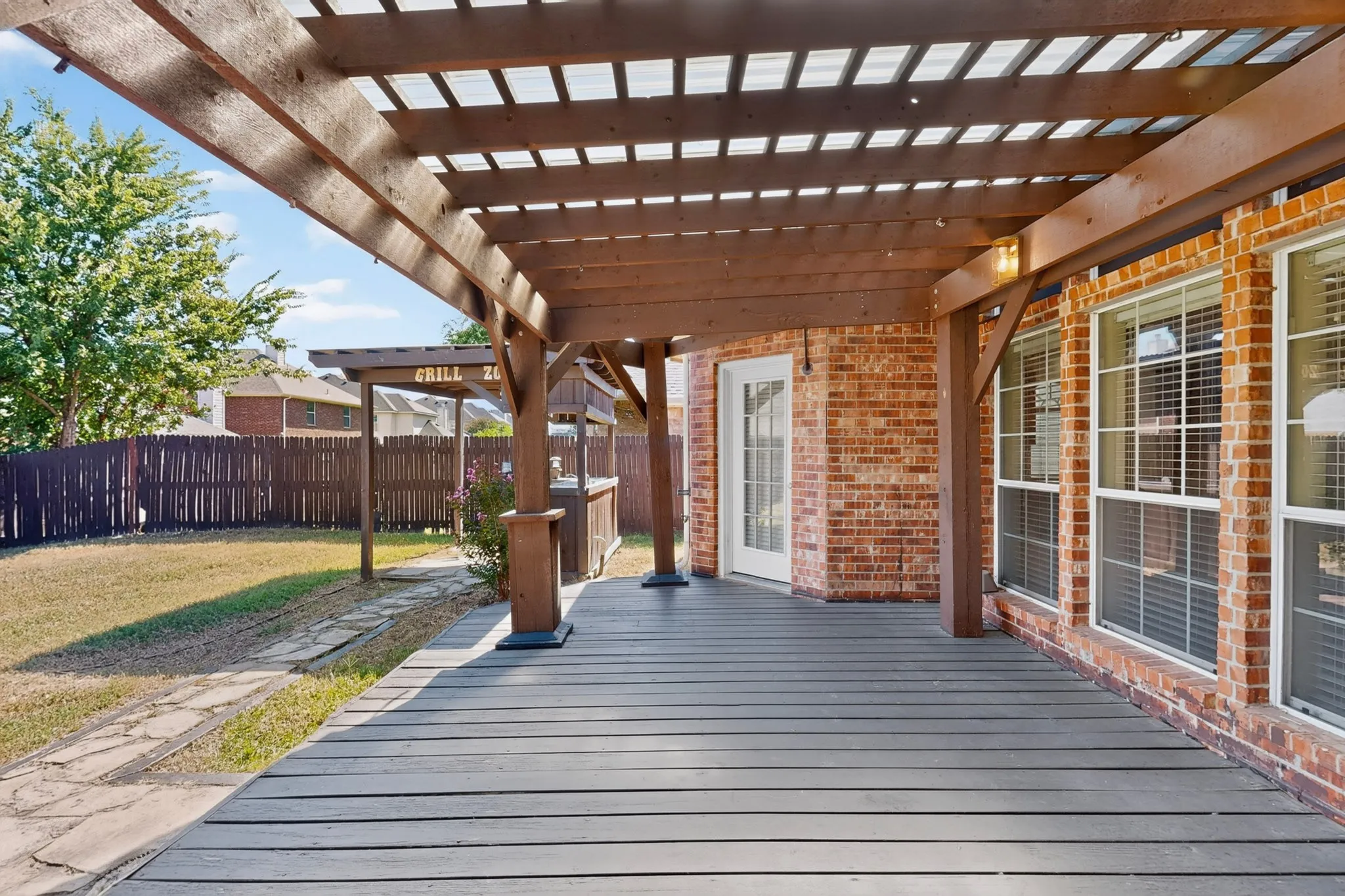 Expansive covered patio with composite decking and exposed wood pergola