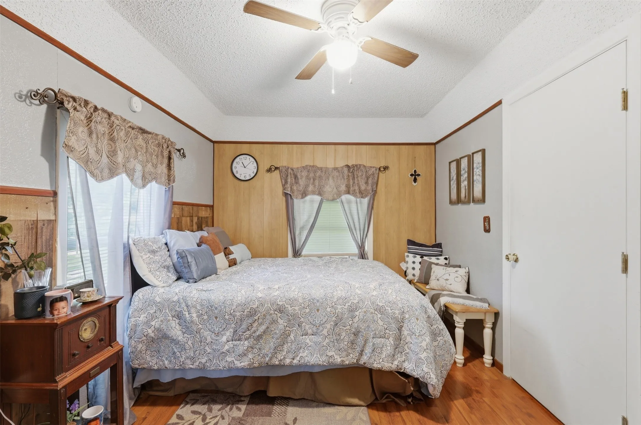 Secondary bedroom with bright window lighting, ceiling fan, neutral walls, and generous floor space.