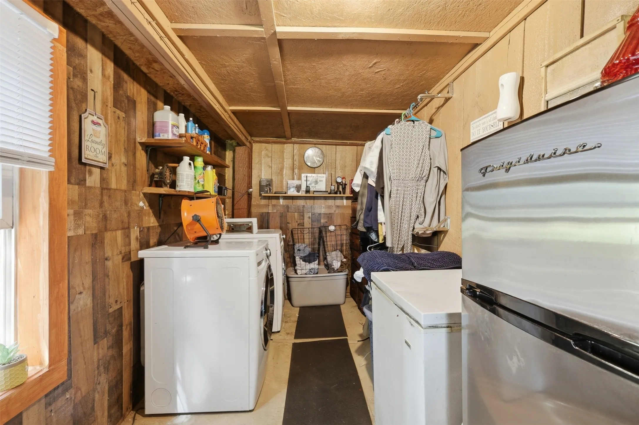Utility and laundry room space fitted with washer/dryer hookups and extra storage shelving.