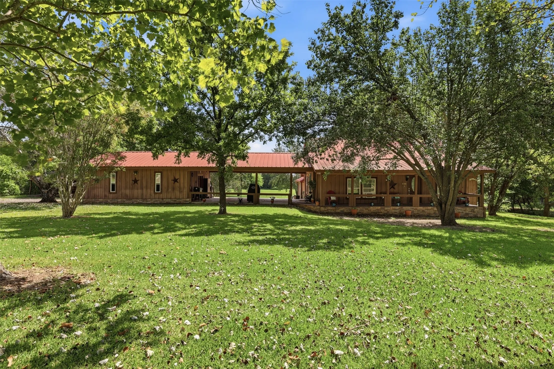 Rear exterior perspective highlighting the ranch layout and open green space.