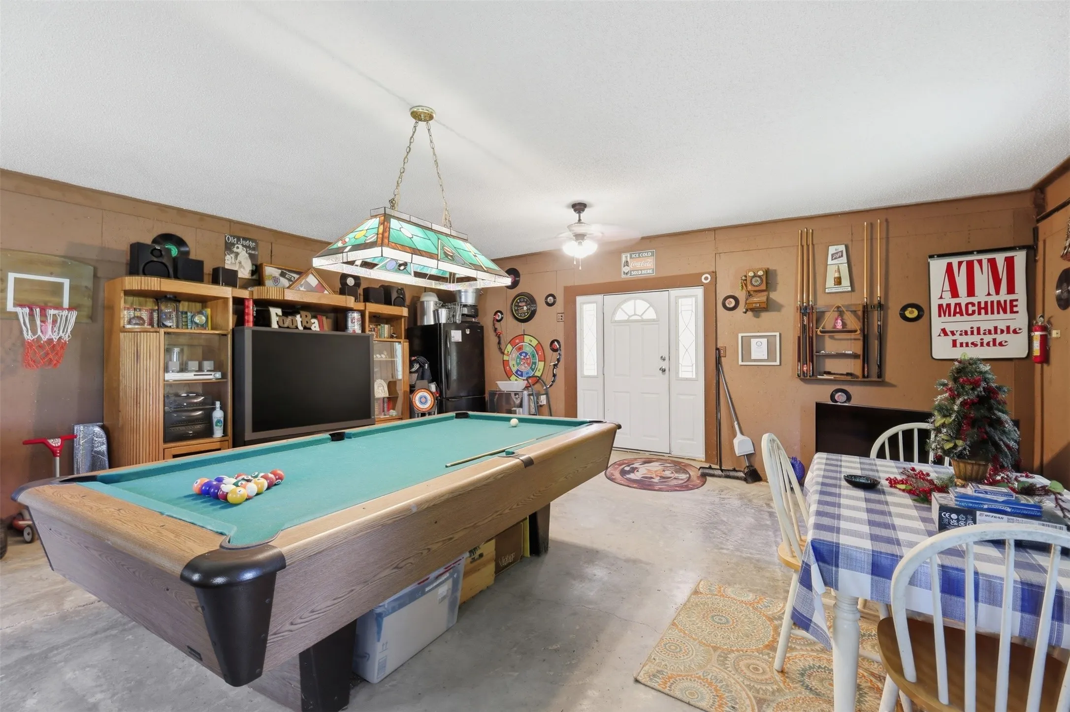 Game room angle showcasing stained-glass hanging fixture, pool table, and comfortable entertainment area.