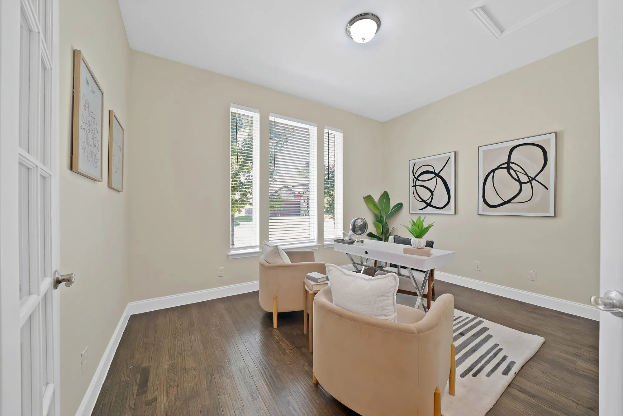 Wood-finish flooring, white trim, and neutral wall paint