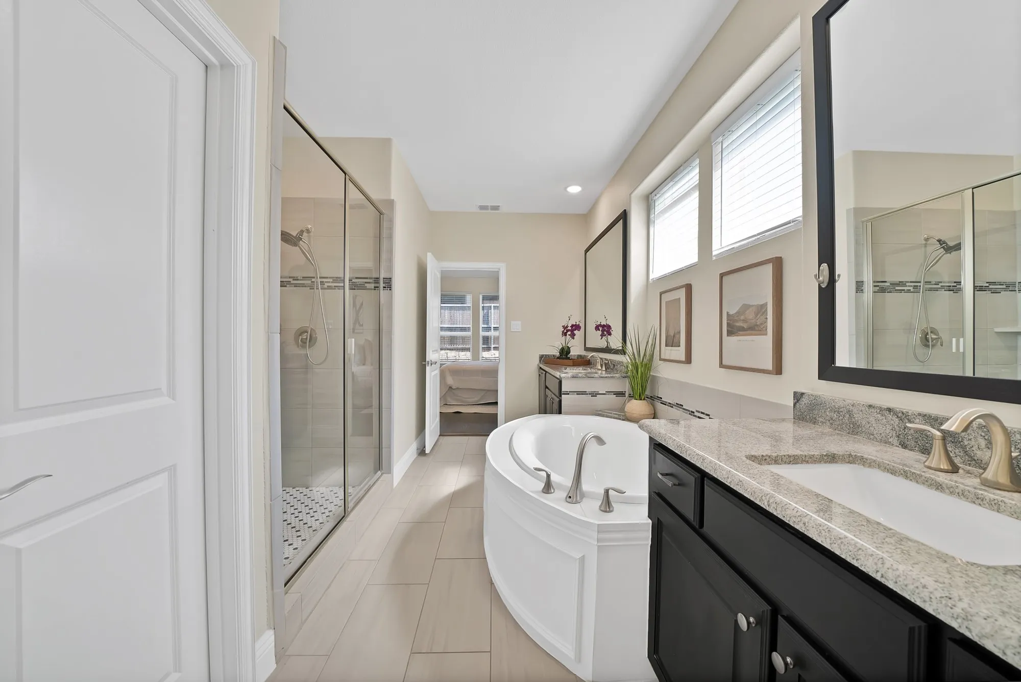 Dual vanity with granite countertops, separate shower enclosure with glass surround, built-in soaking tub, and tile flooring
