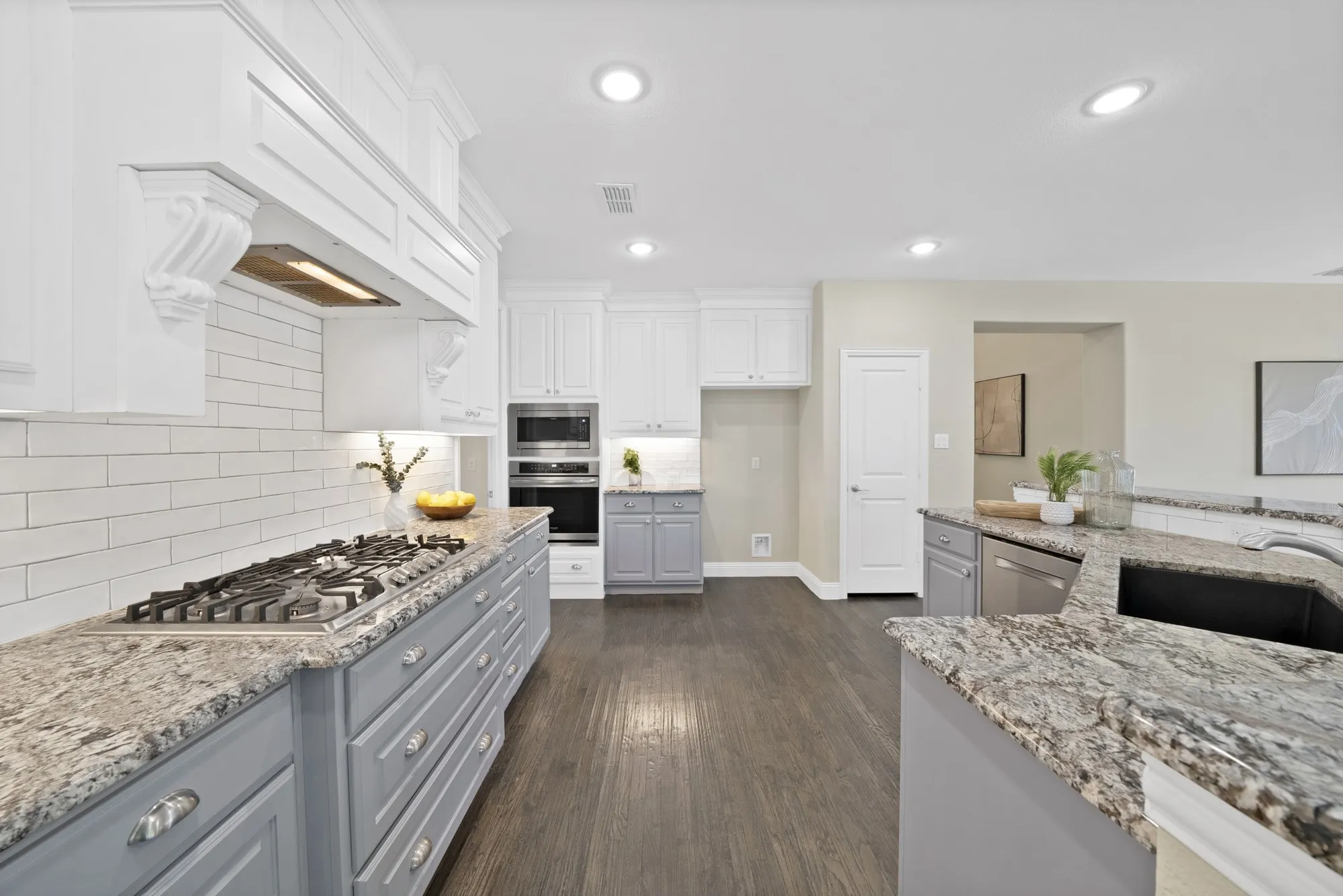 Gourmet kitchen featuring granite countertops, a built-in gas range, white subway tile backsplash, recessed lighting, and wood-finish flooring