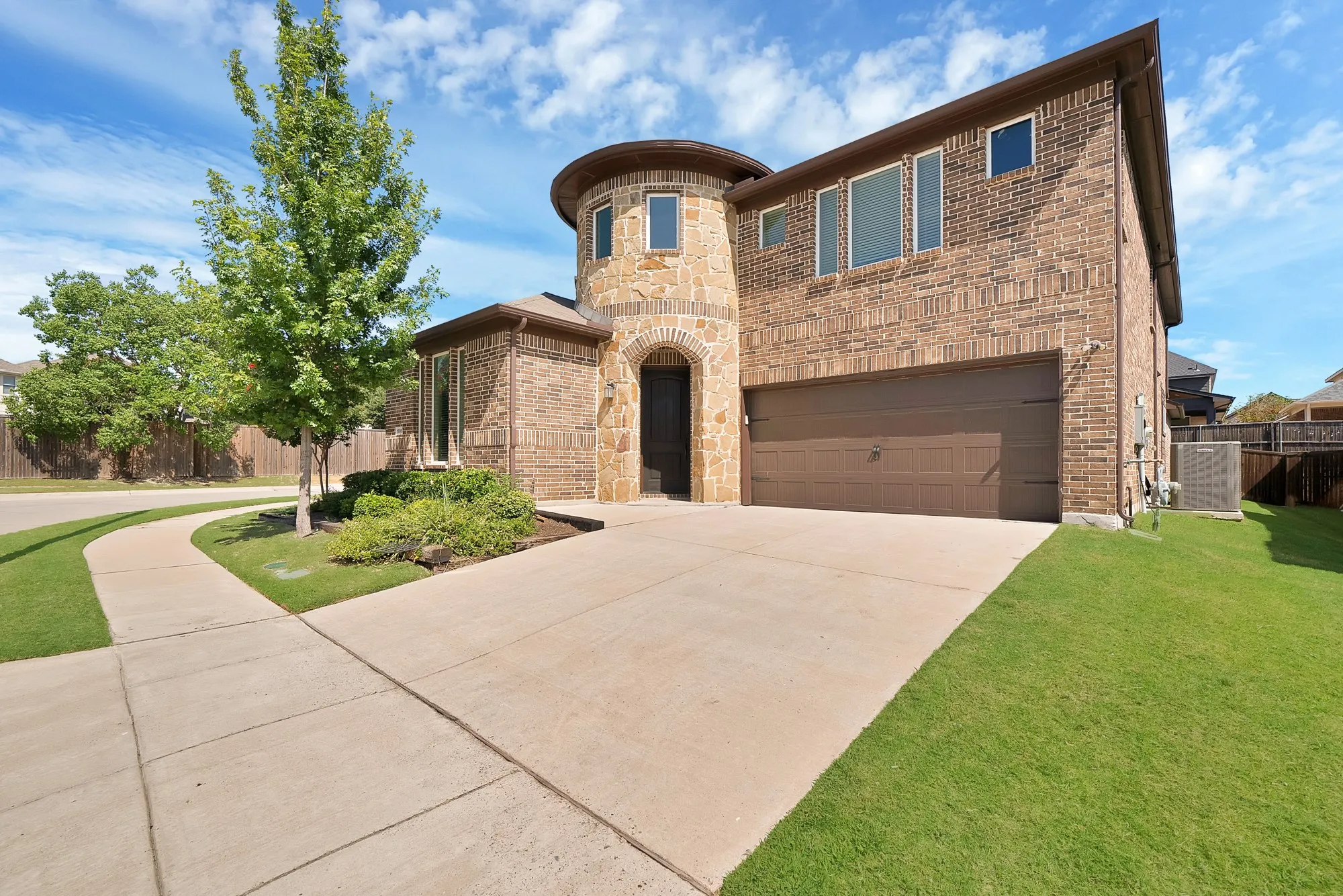 Brick exterior with stone accents, featuring a rounded turret and multiple windows