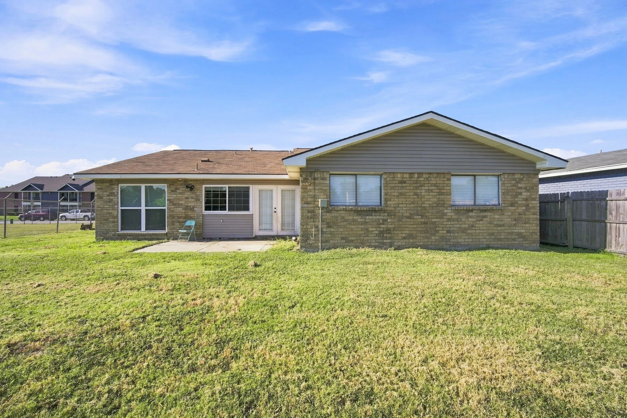 Expansive backyard with a large grass area, a concrete patio, and a privacy fence