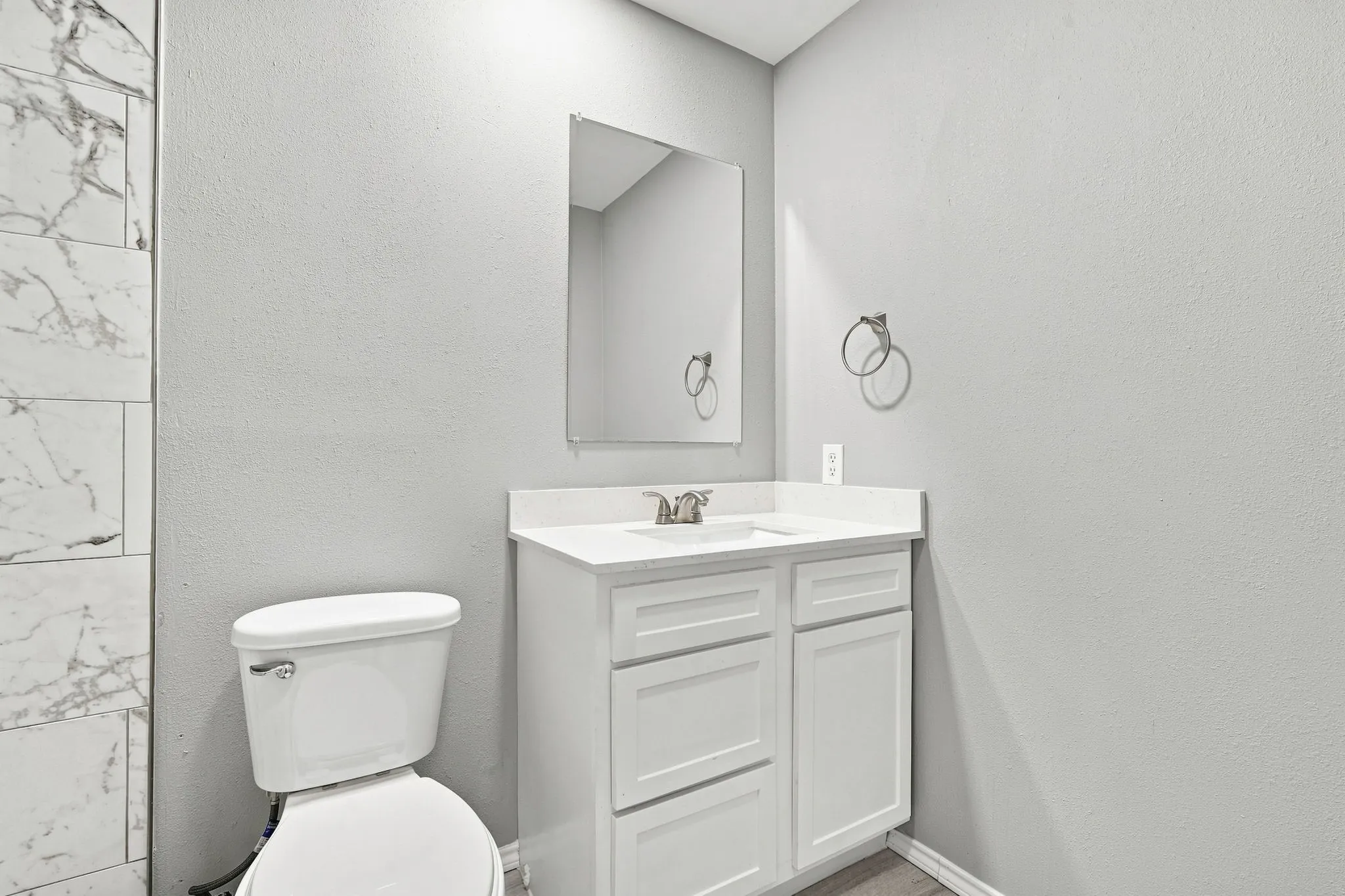 White vanity with an integrated sink, polished chrome faucet, and mirrored cabinet