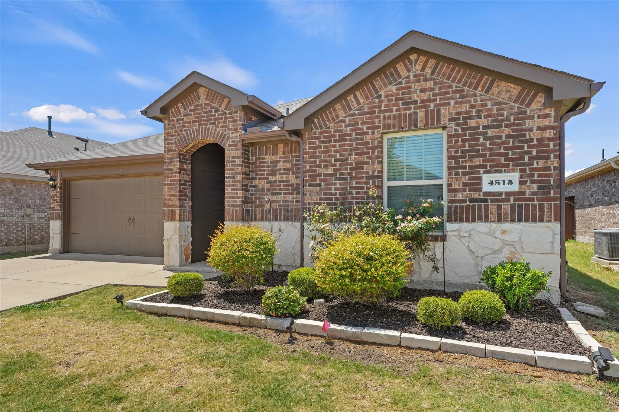 The front garage provides extra parking and beautiful landscaping greets your guests