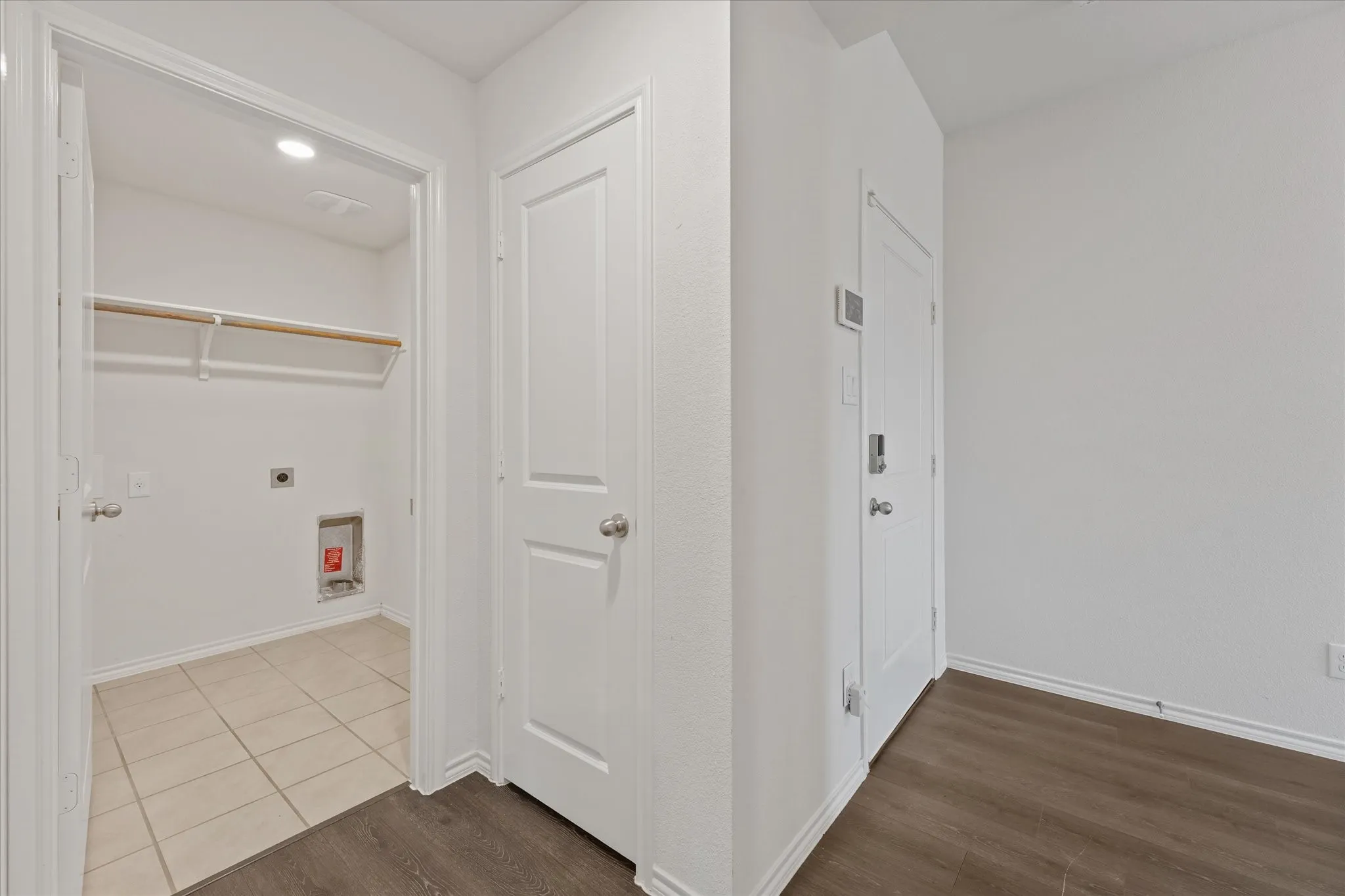 Laundry room with tile flooring, recessed lighting, and shelving