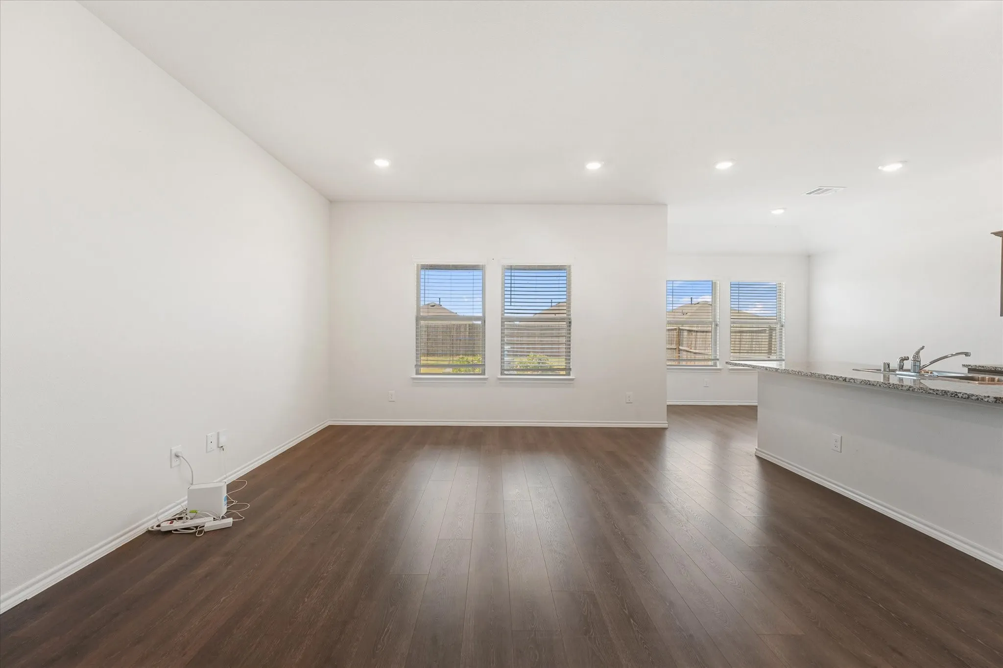 Bright, open living space featuring multiple large windows with expansive sightlines and recessed ceiling lighting