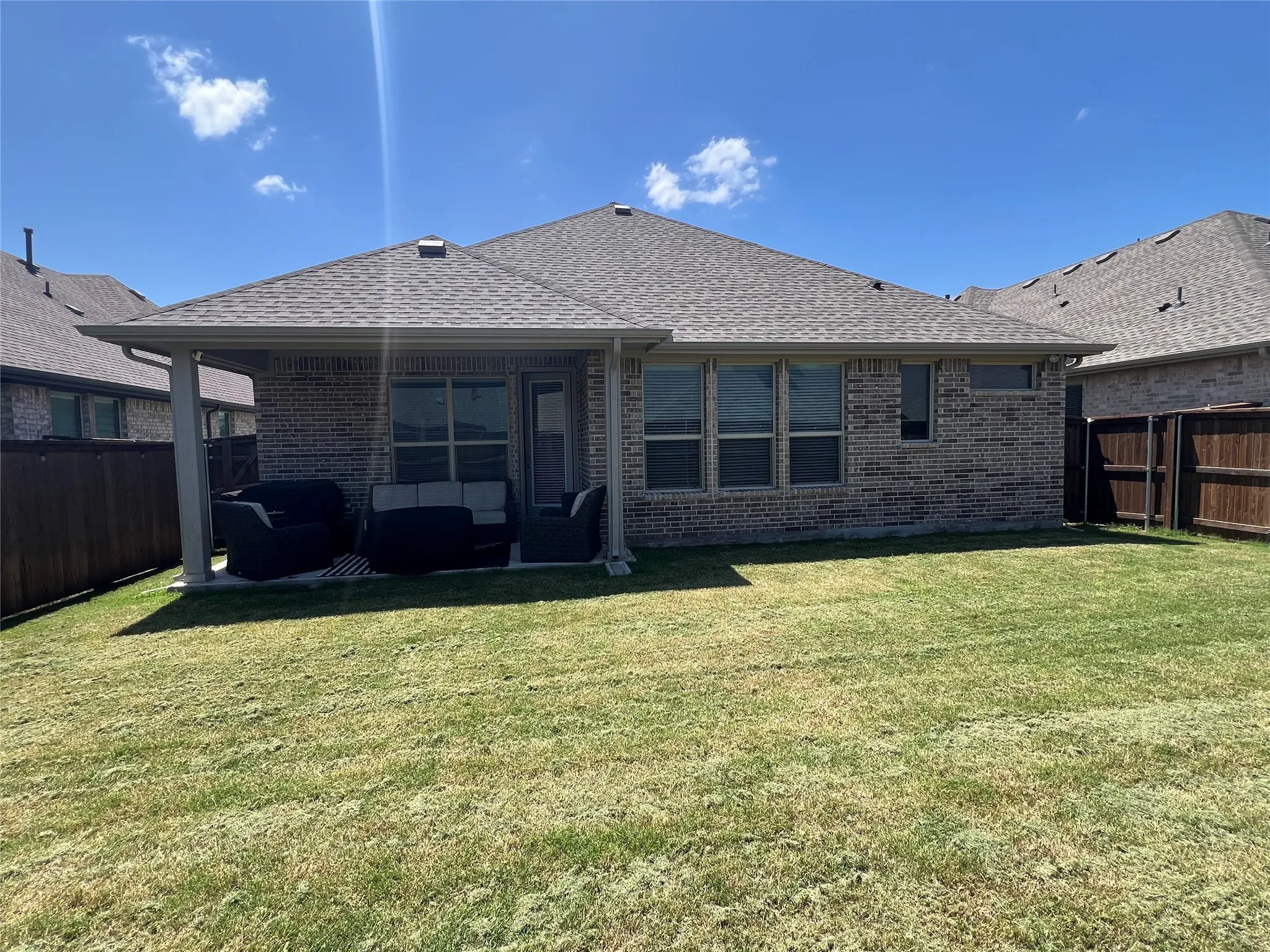 Rear view of property with an outdoor hangout area, a fenced backyard, and brick siding