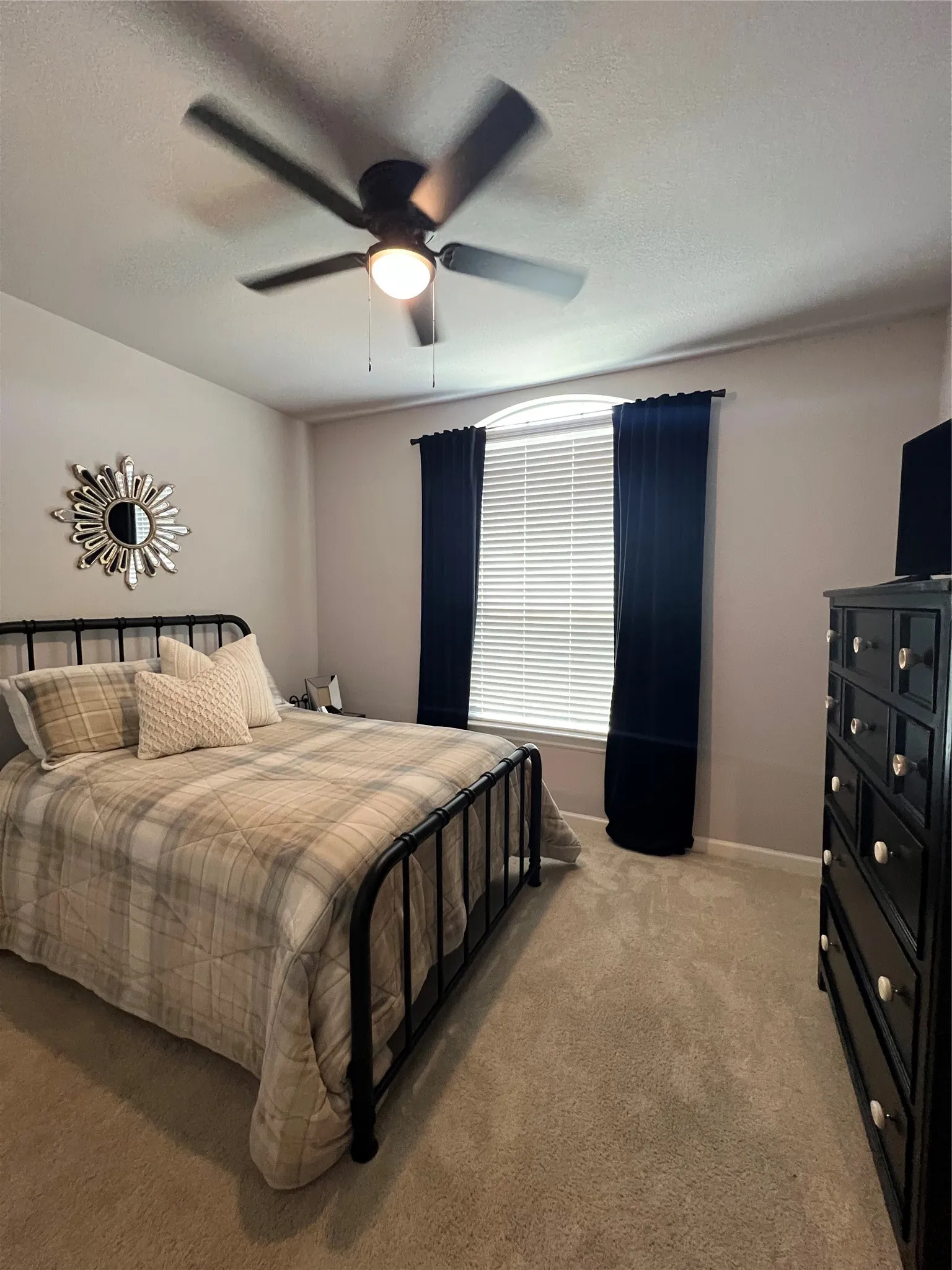 Bedroom featuring light colored carpet, ceiling fan, and a textured ceiling