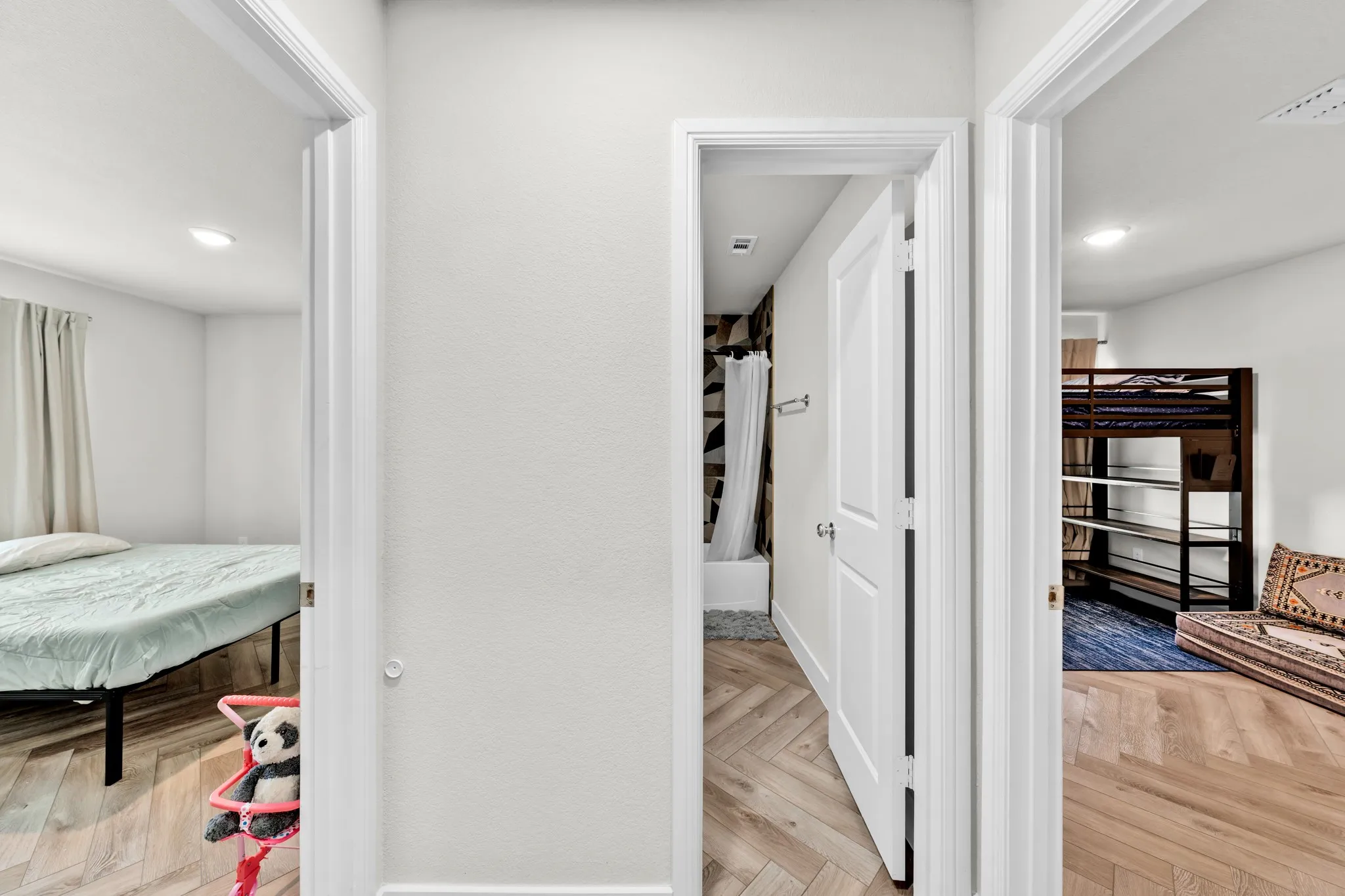 Herringbone wood-finish flooring throughout the hallway and rooms