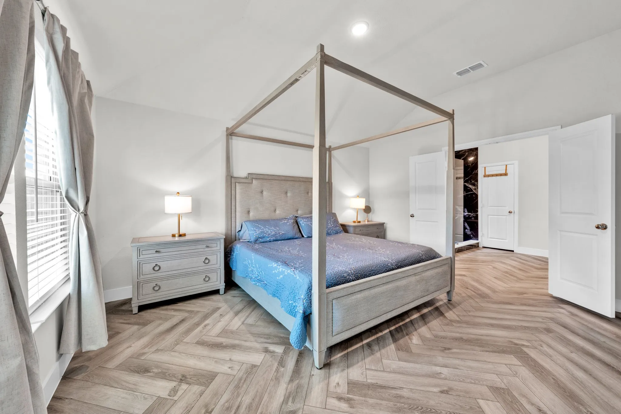 Herringbone wood-finish flooring, recessed lighting, and white paneled doors