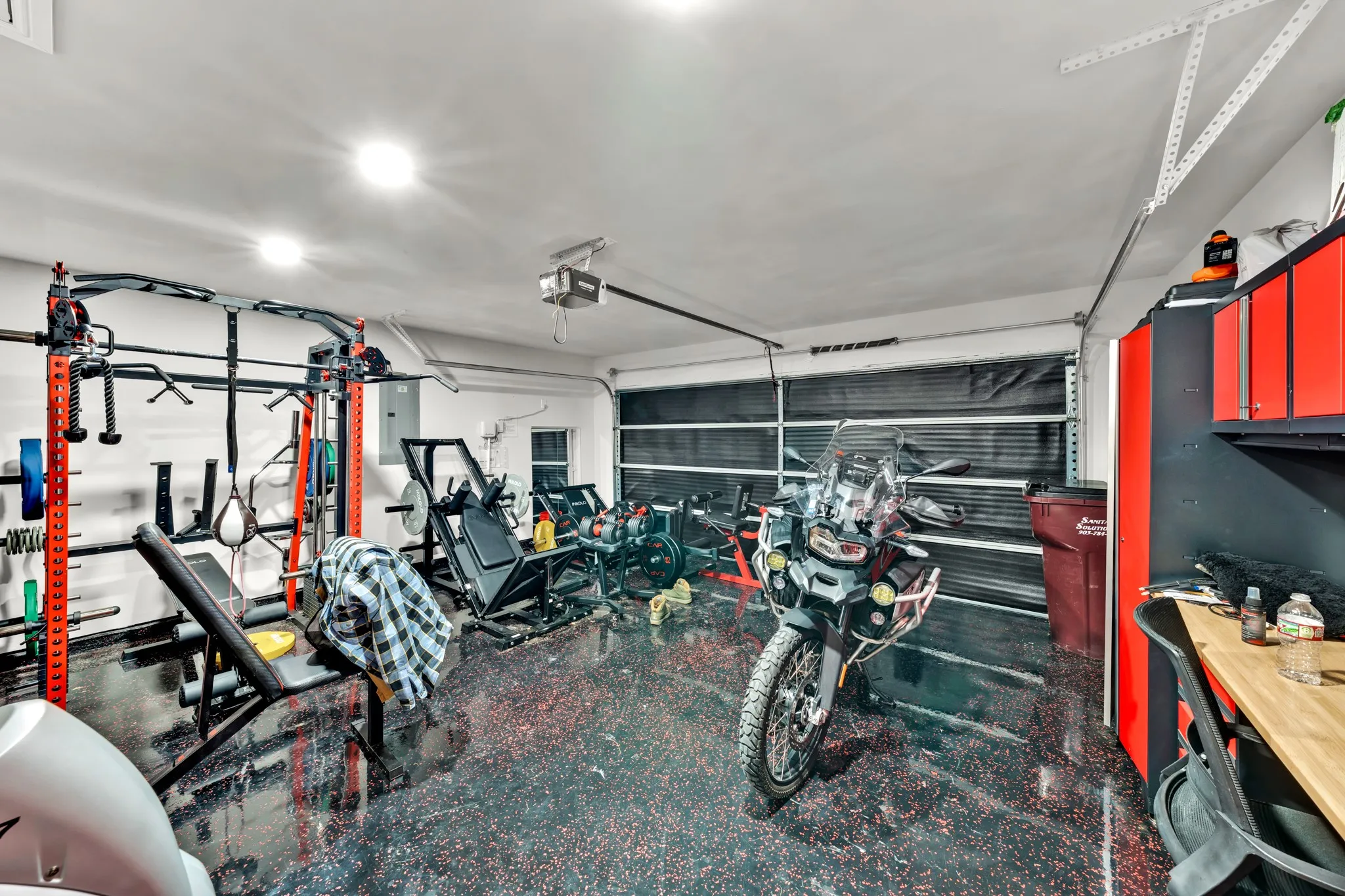 Garage with epoxy flooring, white painted walls, recessed lighting