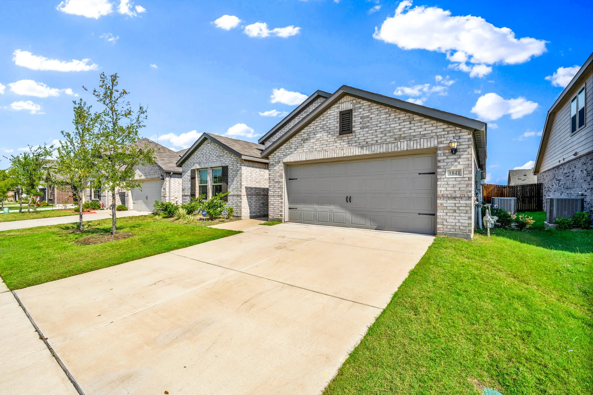 Brick exterior with dark gray trim and a two-car garage