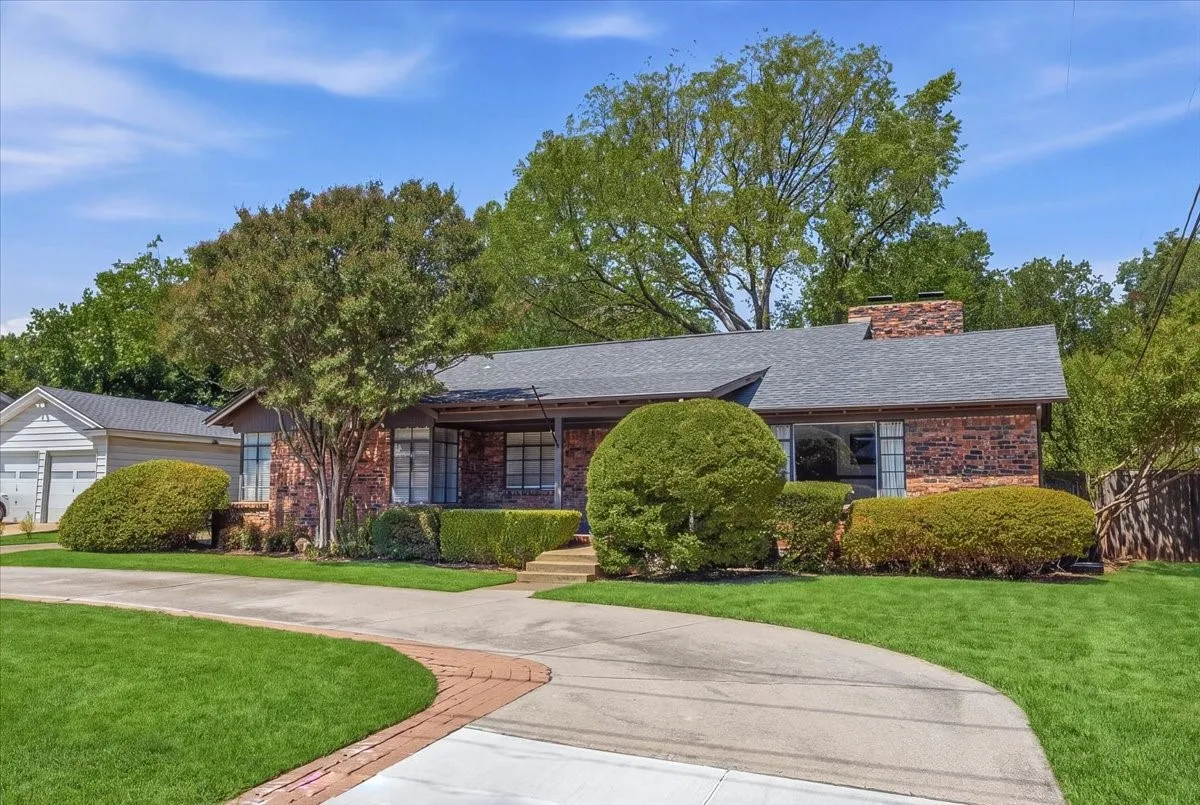 Brick exterior with a covered porch, red entry door, and architectural windows