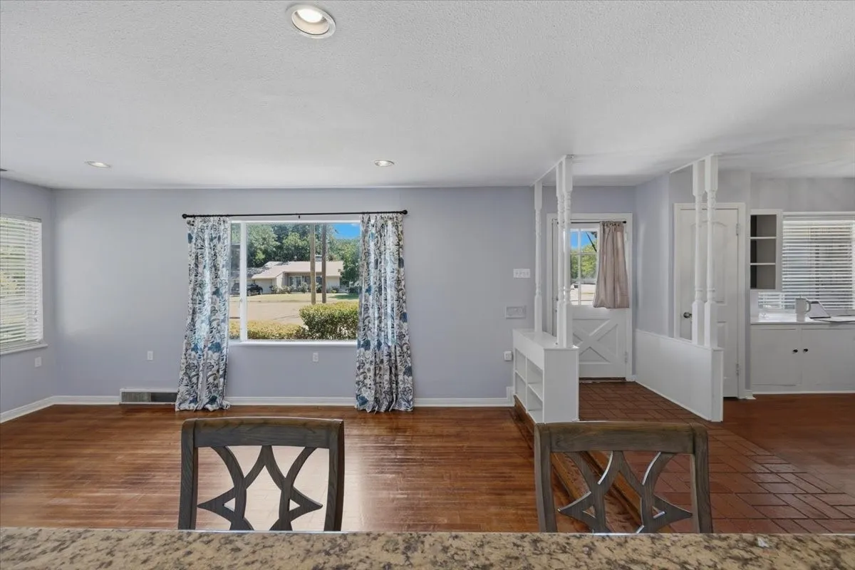 Expansive yard with mature trees, perimeter wood fencing, and a detached structure