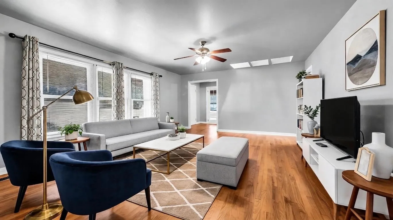 Viturally Staged Living Area.  Home offers Hardwood flooring, multiple large windows, recessed ceiling lights, ceiling fan, and built-in shelving