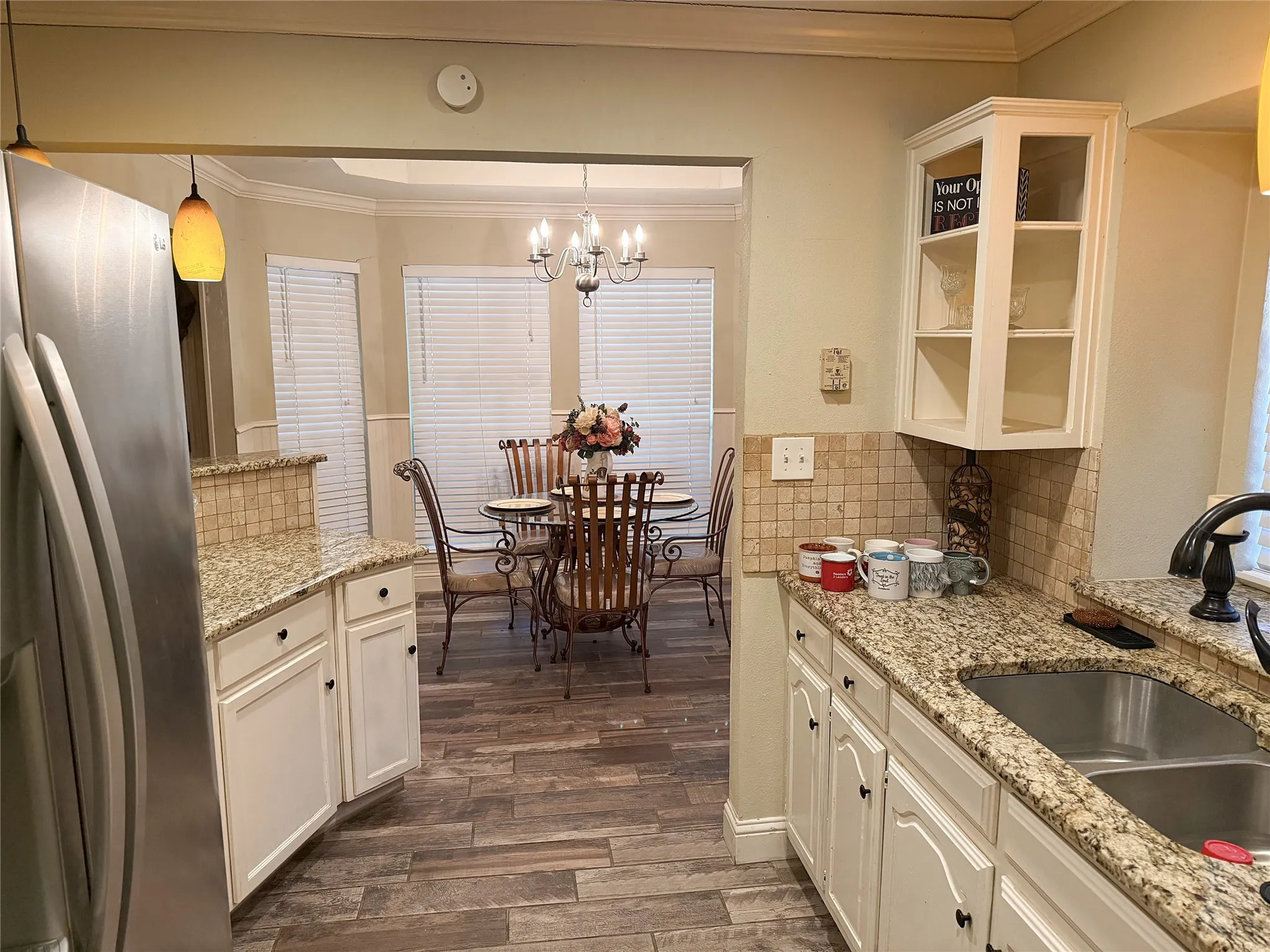 Kitchen featuring light cabinetry, granite countertops, and a tile backsplash