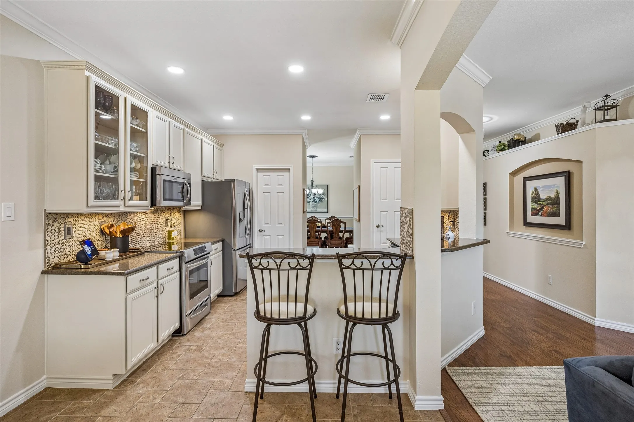 Kitchen with Everyday Convenience - A breakfast bar adds casual seating and serving space, while recessed lighting, updated cabinetry, and an open connection to the family room make the kitchen easy to use and easy to enjoy.