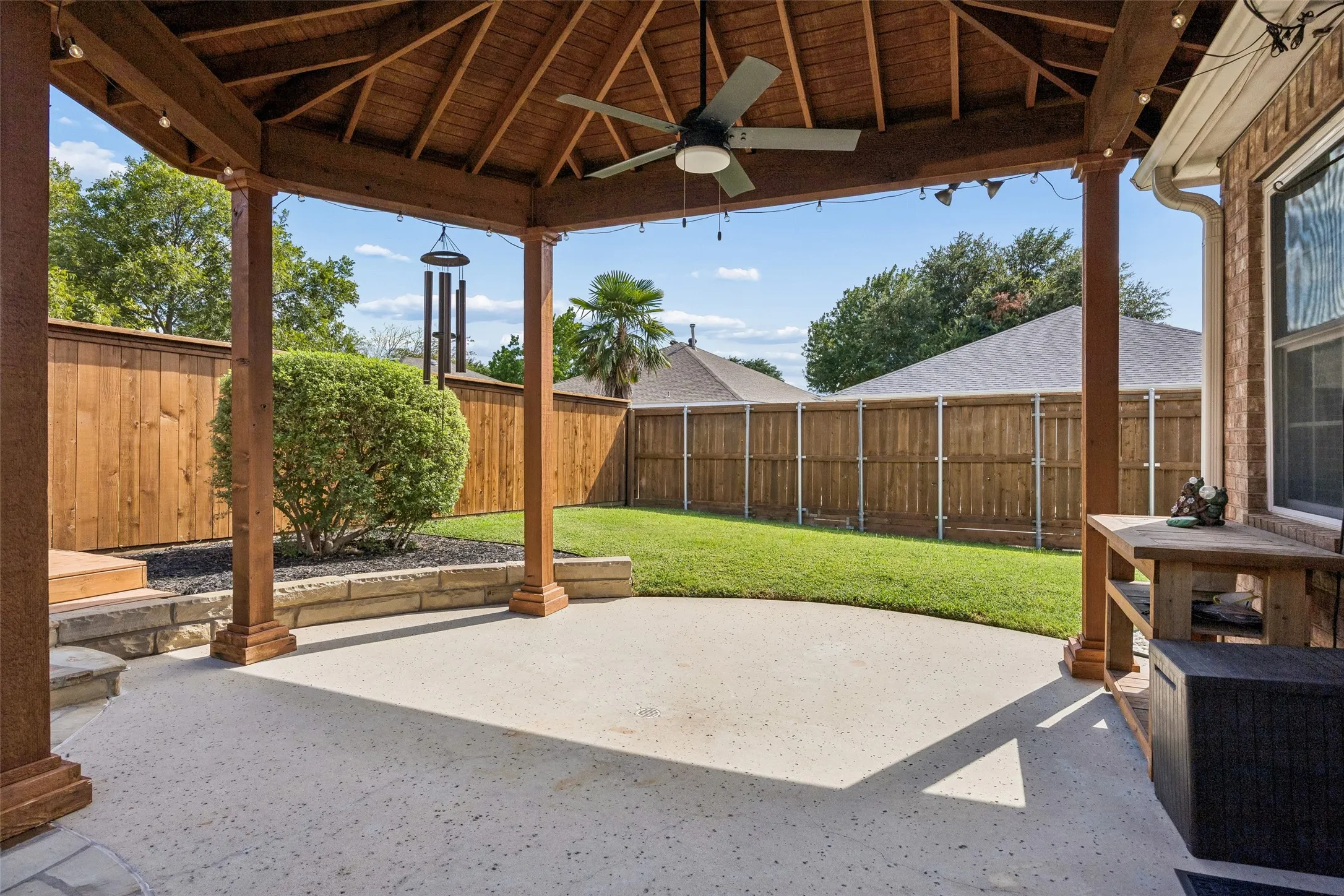 Covered Patio for Shaded Outdoor Living - The roofed patio extends the usable living space outdoors with cedar posts, a cedar ceiling, and a ceiling fan, creating a comfortable spot for relaxing or gathering beside the pool.