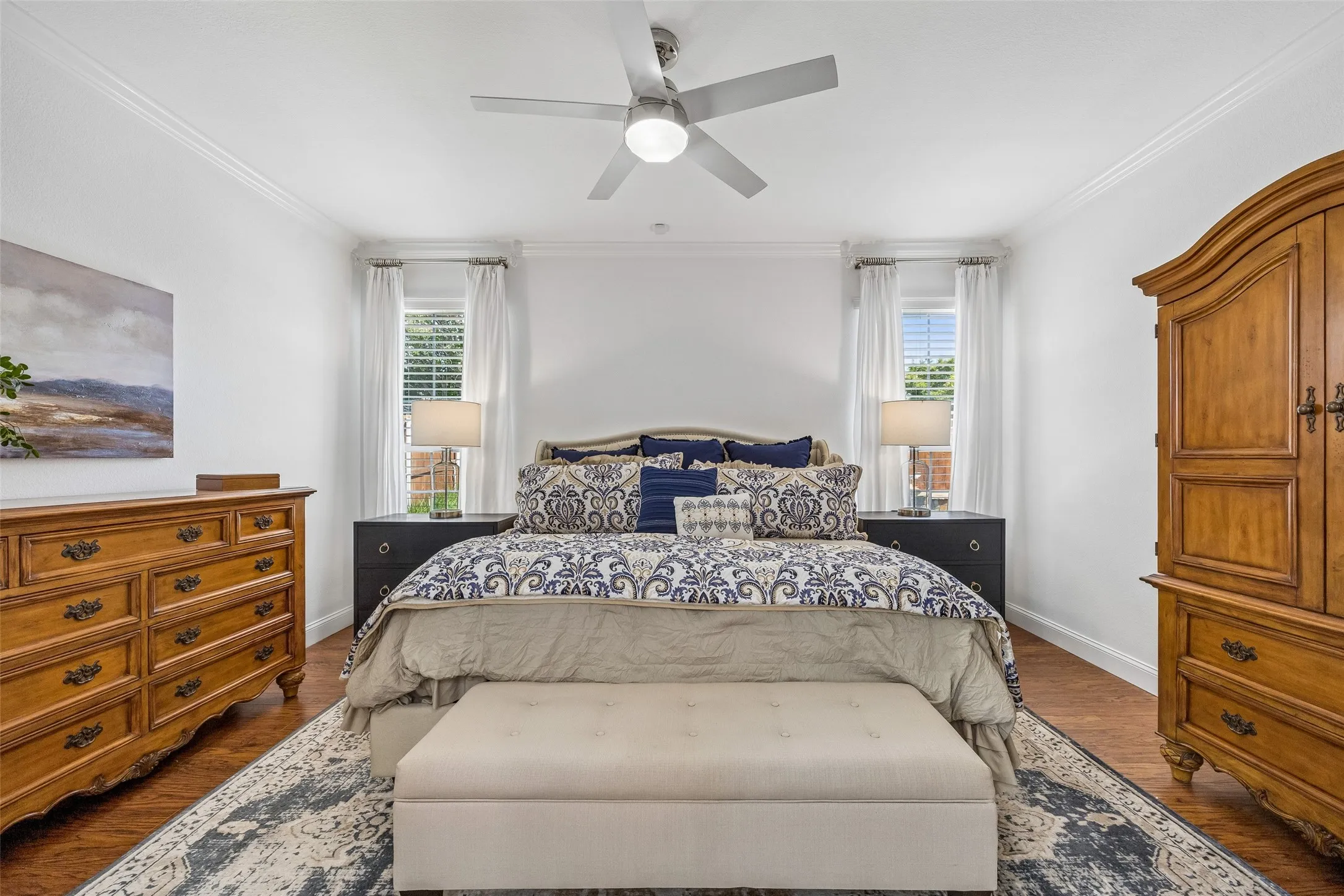 Primary Bedroom with Room to Unwind - Generous proportions, updated flooring, crown molding, and natural light from two windows create a comfortable retreat with plenty of space for substantial furnishings.