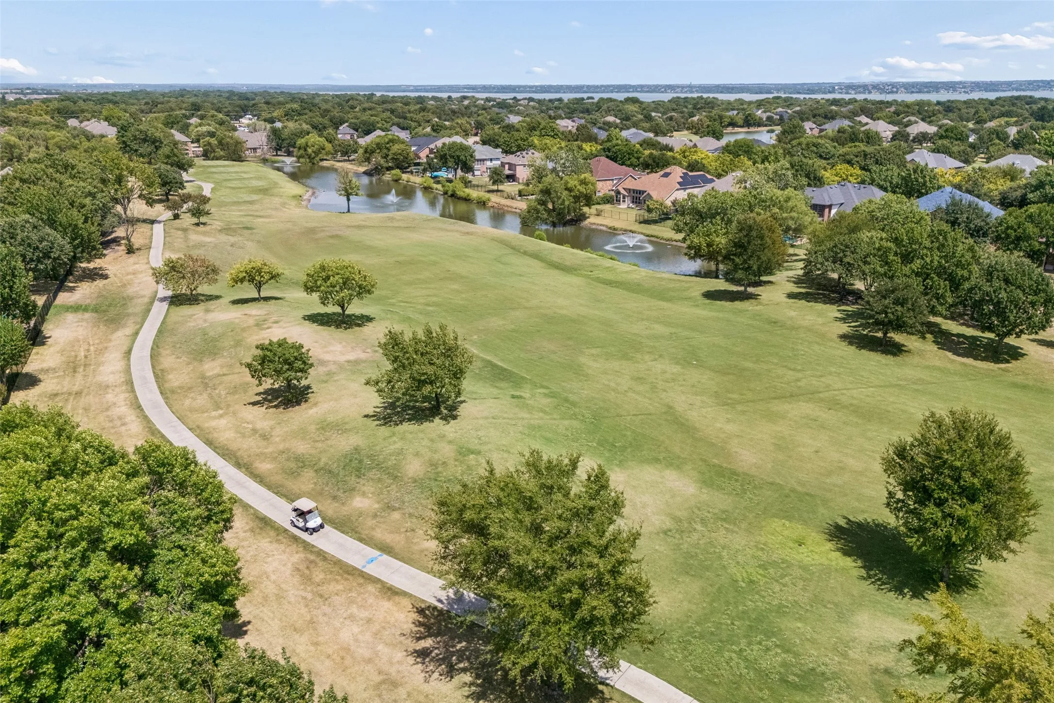 Golf Course and Water Views Nearby - Waterview’s golf course winds through the neighborhood alongside landscaped fairways and water features, with Lake Ray Hubbard visible beyond the community.
