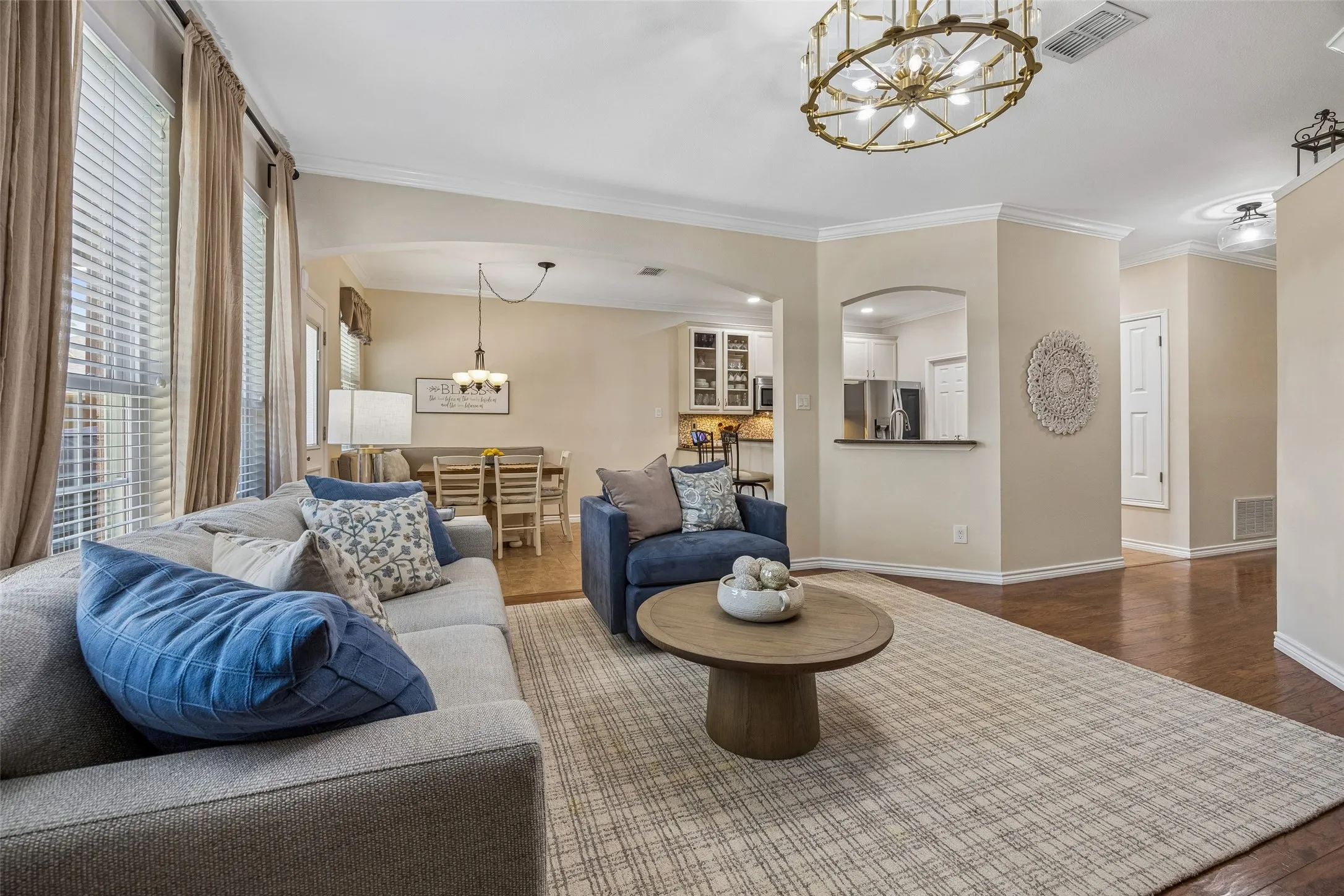 Connected Living with an Open View - From the family room, arched openings create an easy visual connection to the breakfast area and kitchen, while large windows bring in natural light and help the main living spaces feel open and connected.