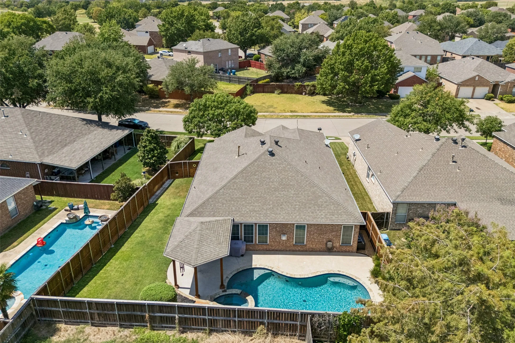 Room to Enjoy the Outdoors - The aerial view highlights the relationship between the home, pool, patio cover, landscaped yard, and privacy fencing, all arranged to make the backyard feel both functional and inviting.