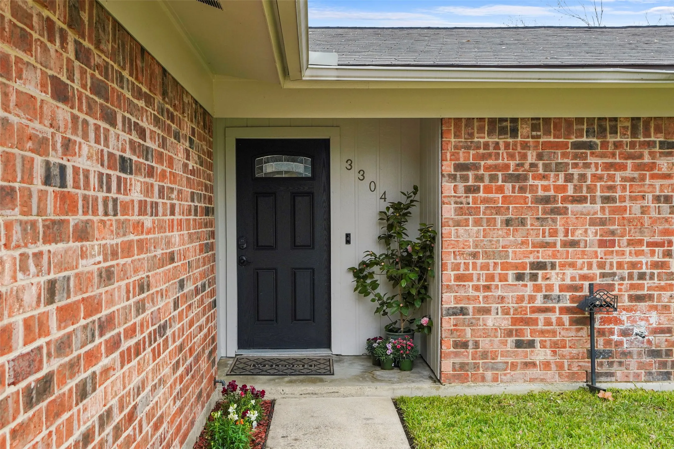 Brick exterior featuring a paneled entry door with a decorative glass insert