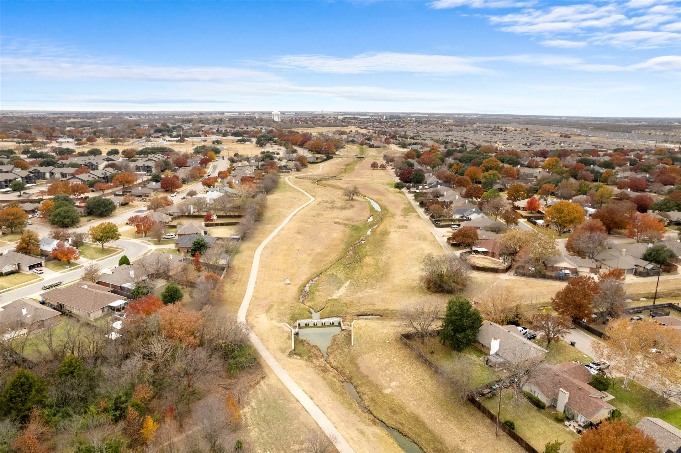 Residential area featuring an extensive greenbelt with walking paths and a waterway