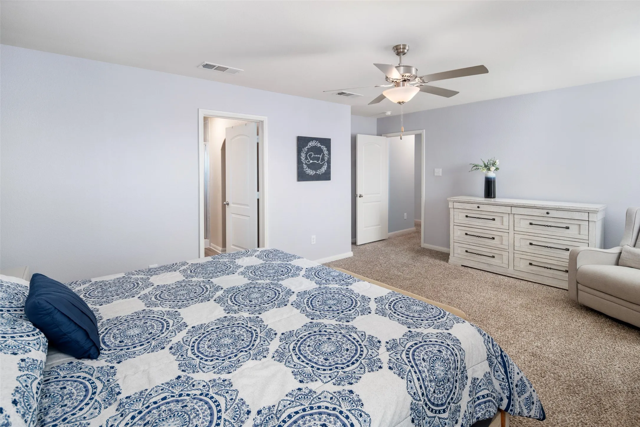 Spacious primary bedroom featuring neutral wall finishes, wood-finish flooring throughout, and abundant natural light
