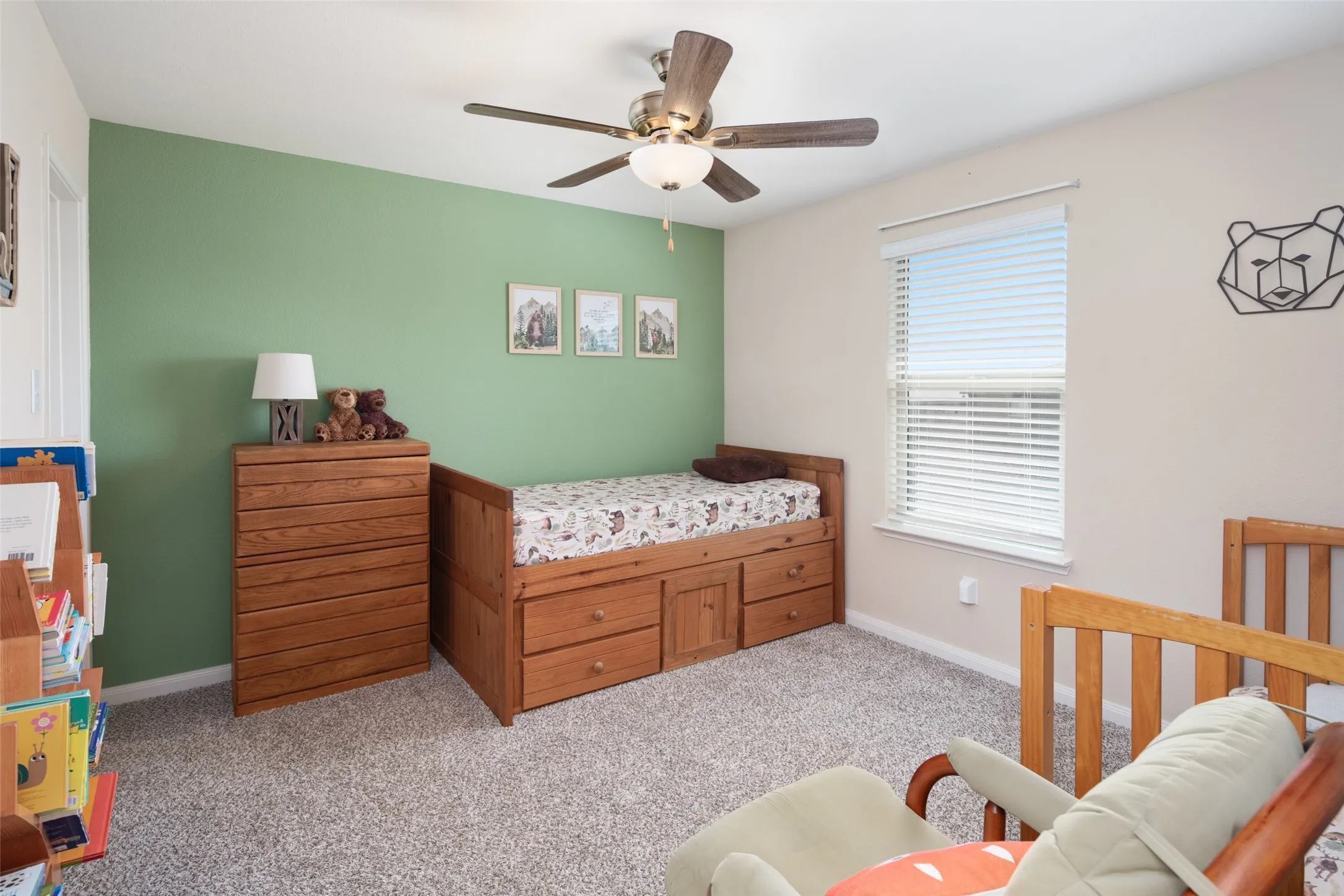 Textured carpeting, window with blinds, overhead ceiling fan with lighting, and a neutral wall color