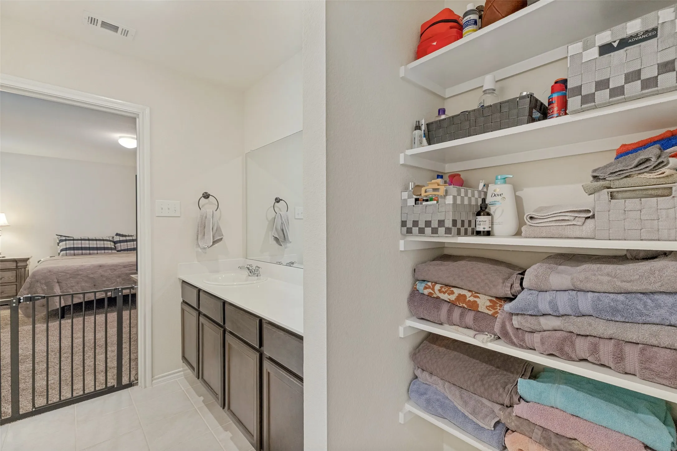 Integrated vanity with an undermount sink, dark wood-finish cabinetry, and a large wall-mounted mirror