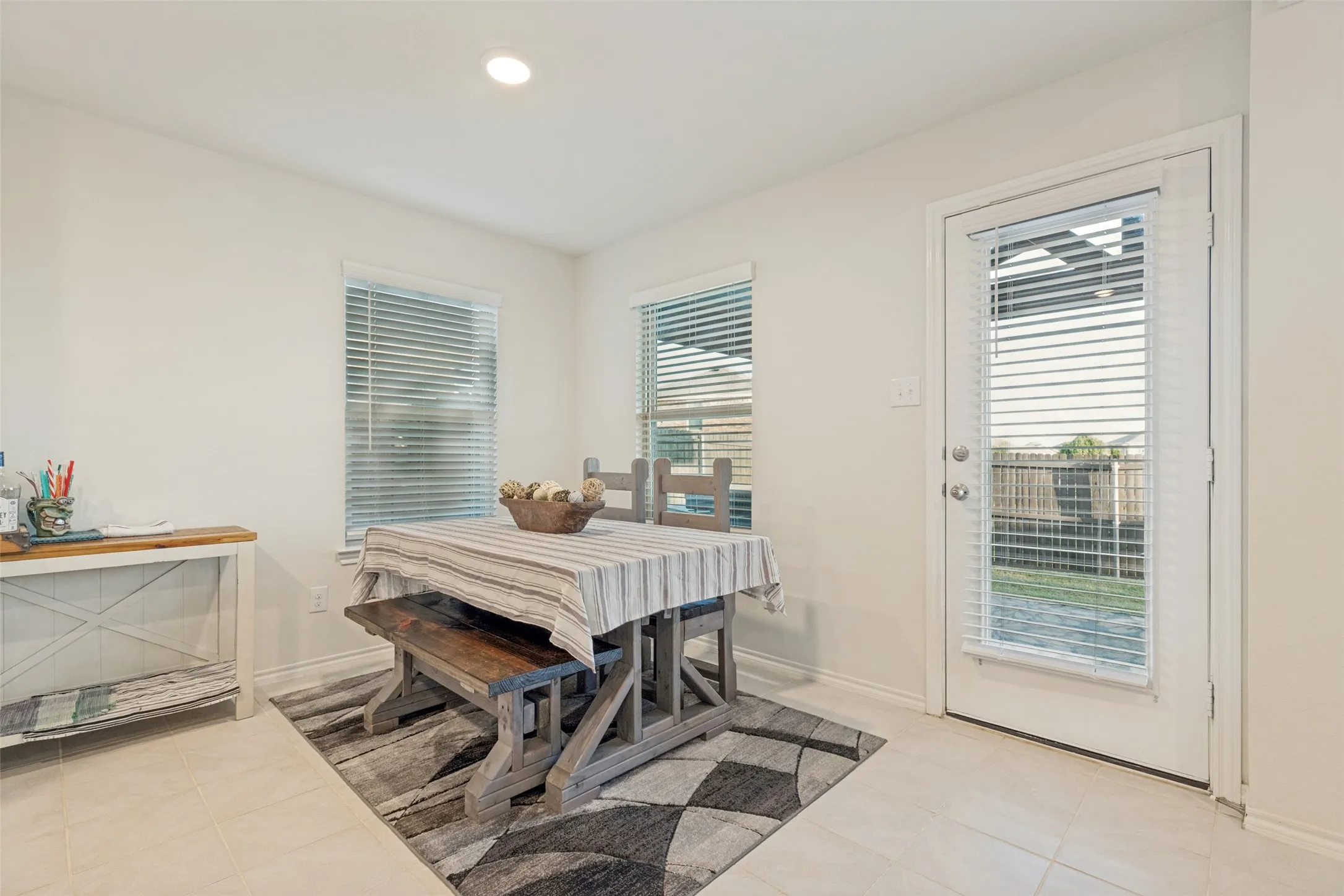 Recessed lighting, tile flooring, multiple windows with blinds, and a white paneled door