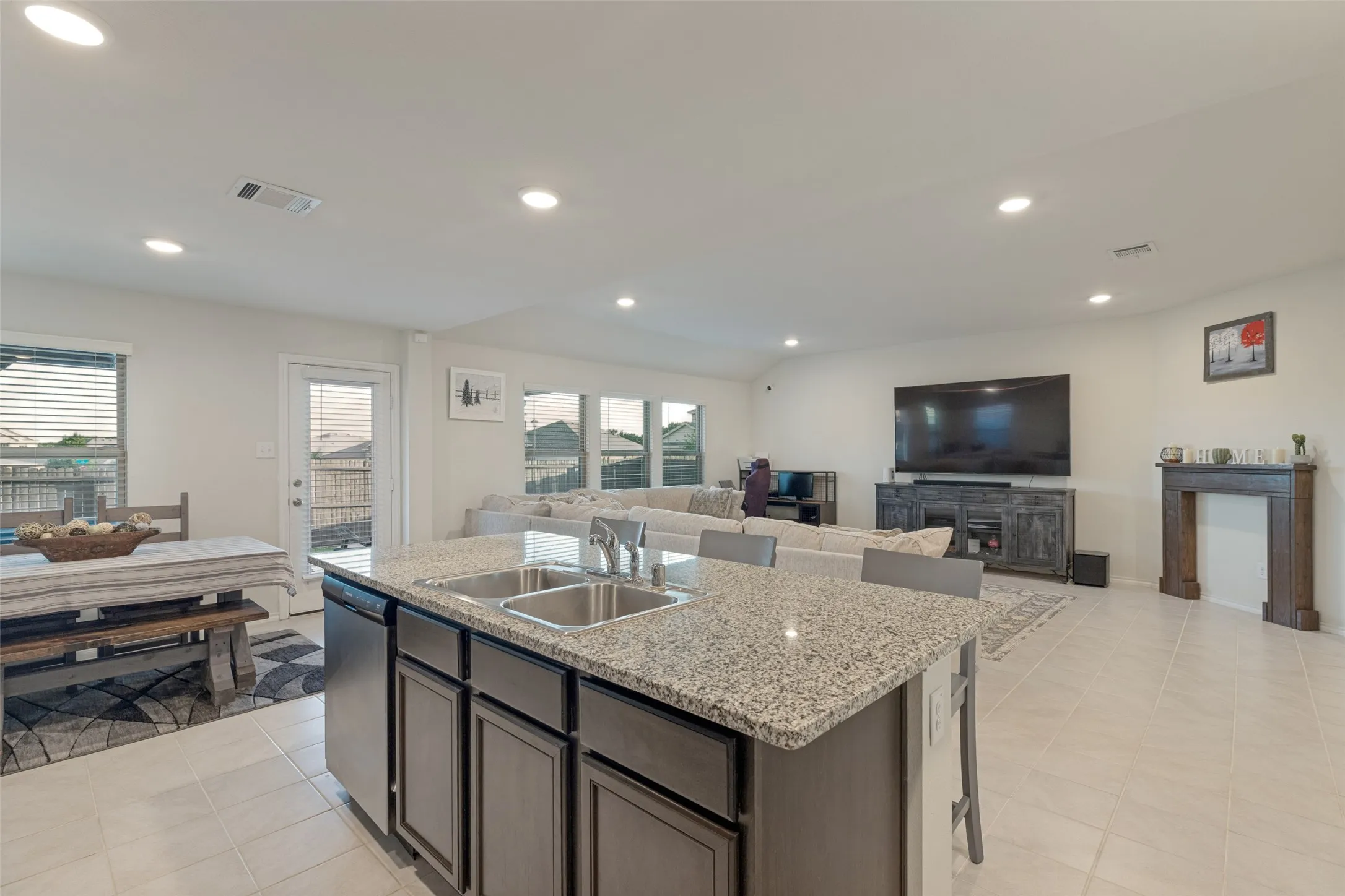 Kitchen island with granite countertop, double stainless steel sink, and dishwasher