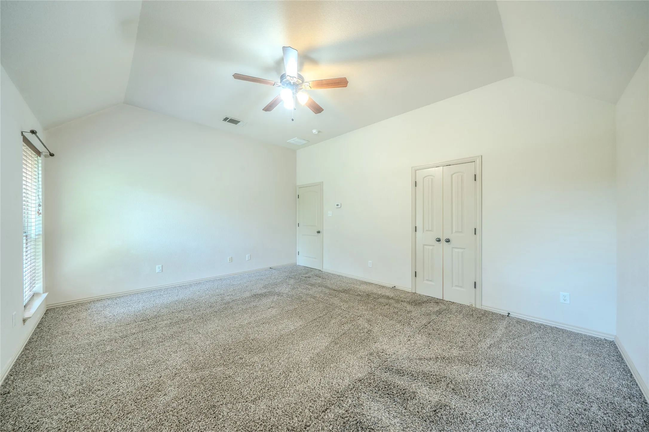 Vaulted ceiling in primary bedroom.