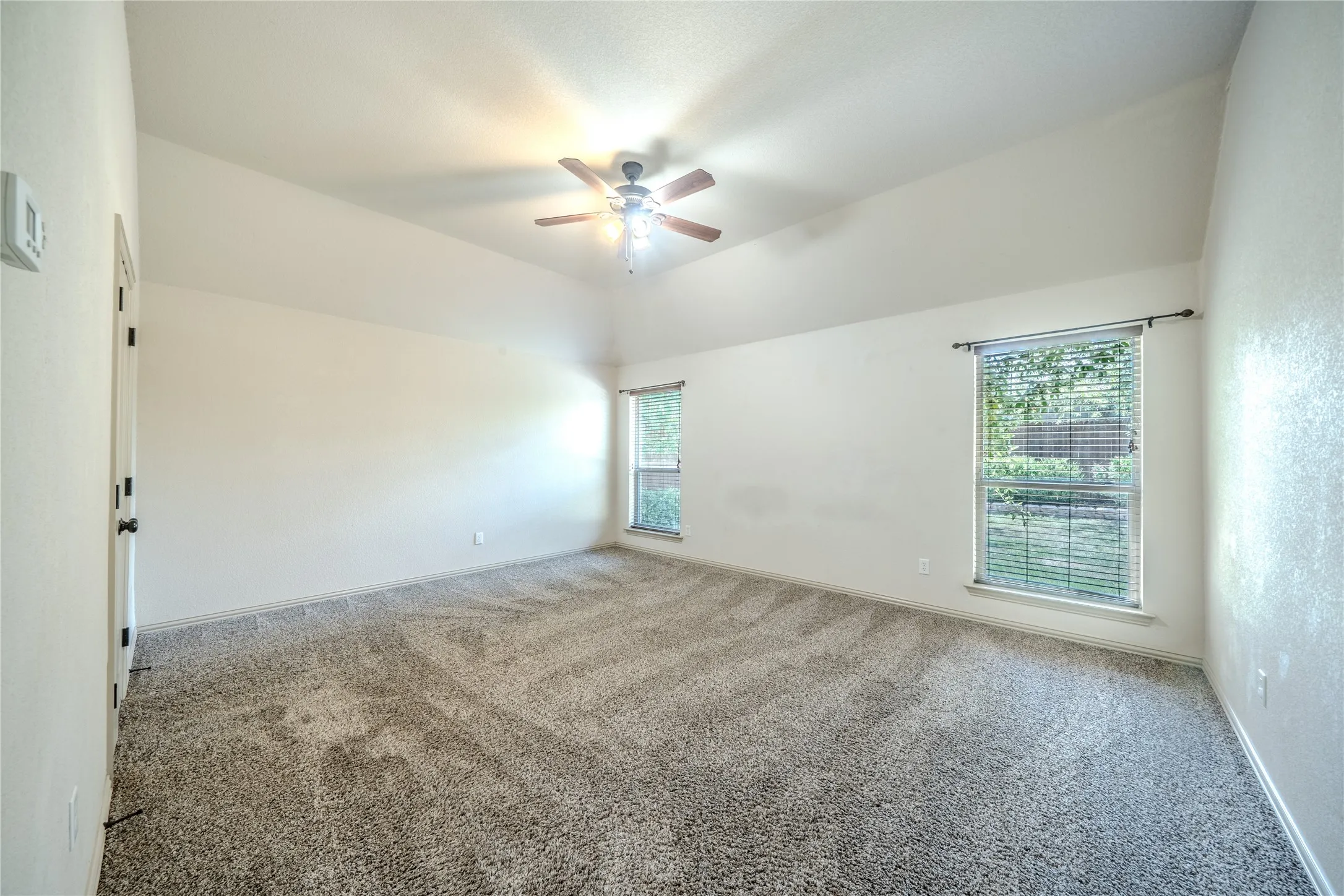 Primary bedroom with ceiling fan and easy entry to en suite bath.