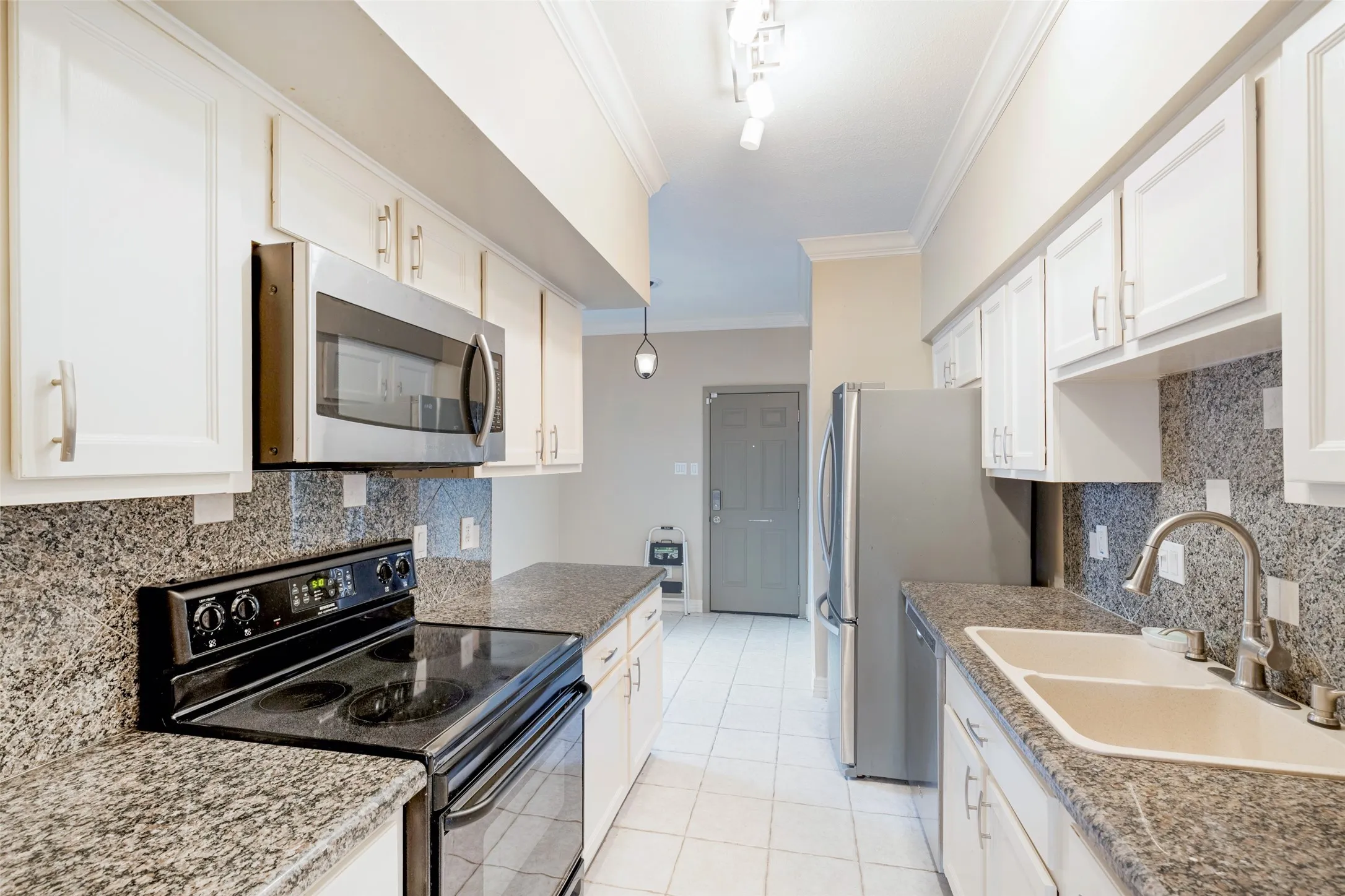 White cabinetry, stainless steel appliances, speckled stone countertops, dual basin sink, and tile flooring